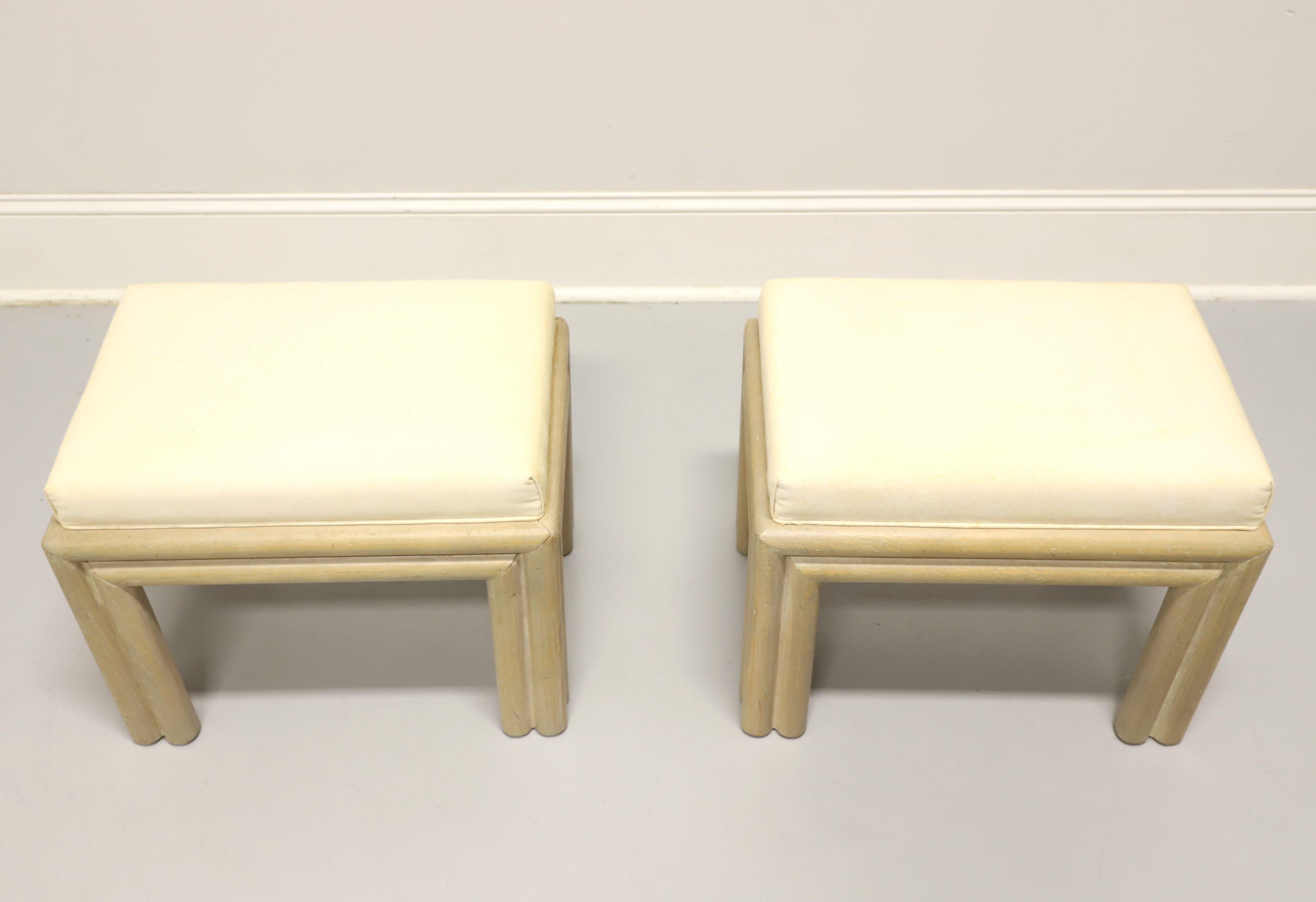 A pair of Contemporary coastal style bench footstools by Hammary, of Lenoir, North Carolina, USA. Solid oak with an antiqued slightly distressed finish, neutral cream color fabric upholstered seat, rounded apron, and rounded straight legs. Made