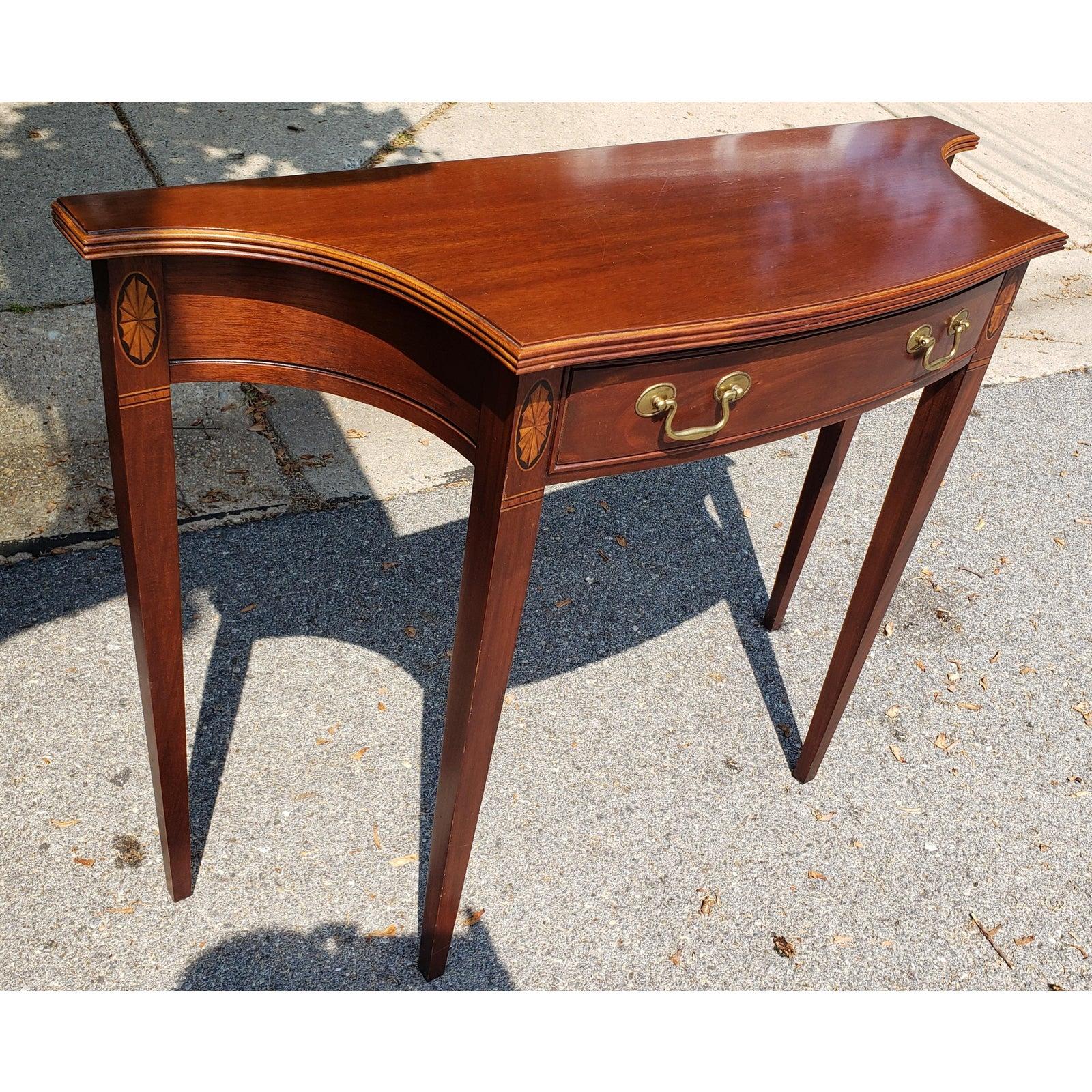 A beautifully contoured, highly versatile piece of solid mahogany console or hall table made by Hammary. This lovely piece features a striking mahogany grain and real wood inlay. It measures 42” x 14”, stands 32” tall, and is in excellent condition.