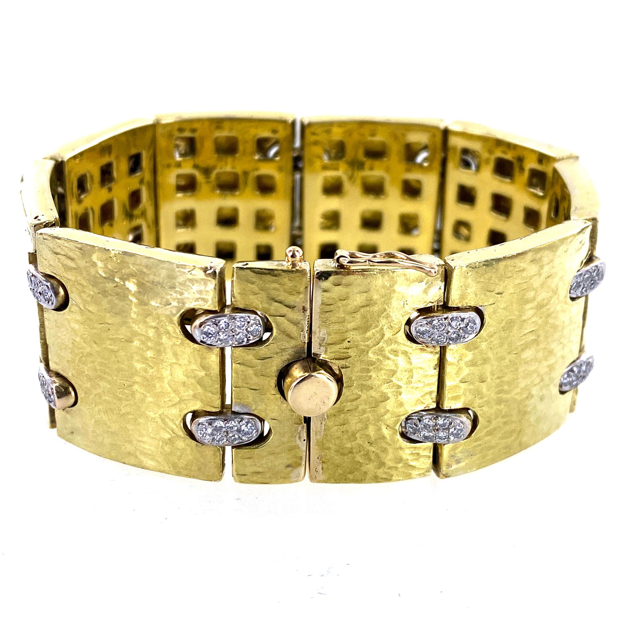 Fabulous hammered satin finish 18 karat yellow gold bracelet connected by diamond links in 18 karat white gold. The diamonds weigh approximately 1.50 carat total weight. The solid gold bracelet measures 7.5 inches in length and 1.0 inch in width. 