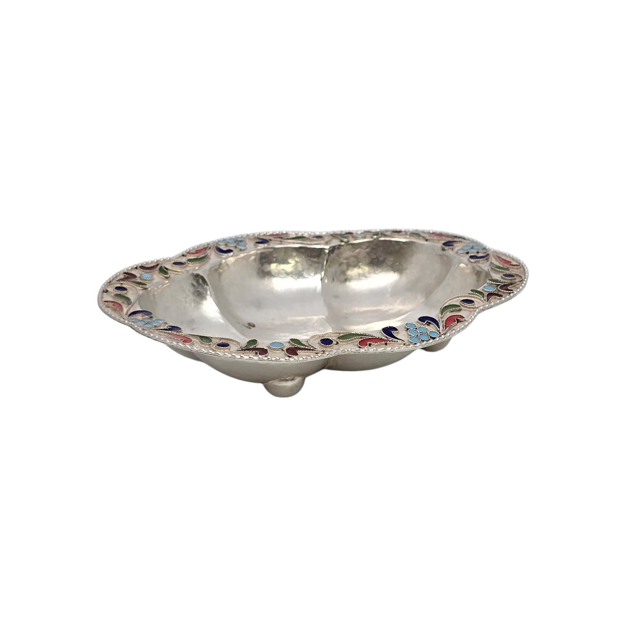 Plat à noix en argent 950 martelé et émaillé.

Ce magnifique petit plat est fabriqué en argent pur à 95 % de haute qualité et présente une finition légèrement martelée avec des motifs de volutes et de cercles en émail de couleur vive autour du bord