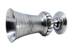 Hammered and fluted silver chalice, resting on a base with engraved plant motifs