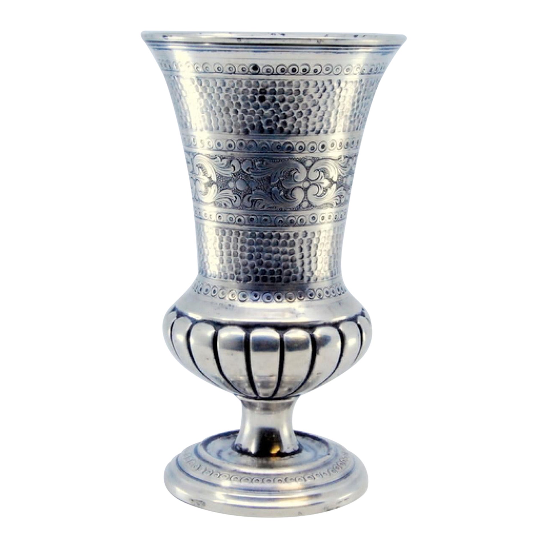 Hammered and fluted silver chalice, resting on a base with engraved plant motifs
