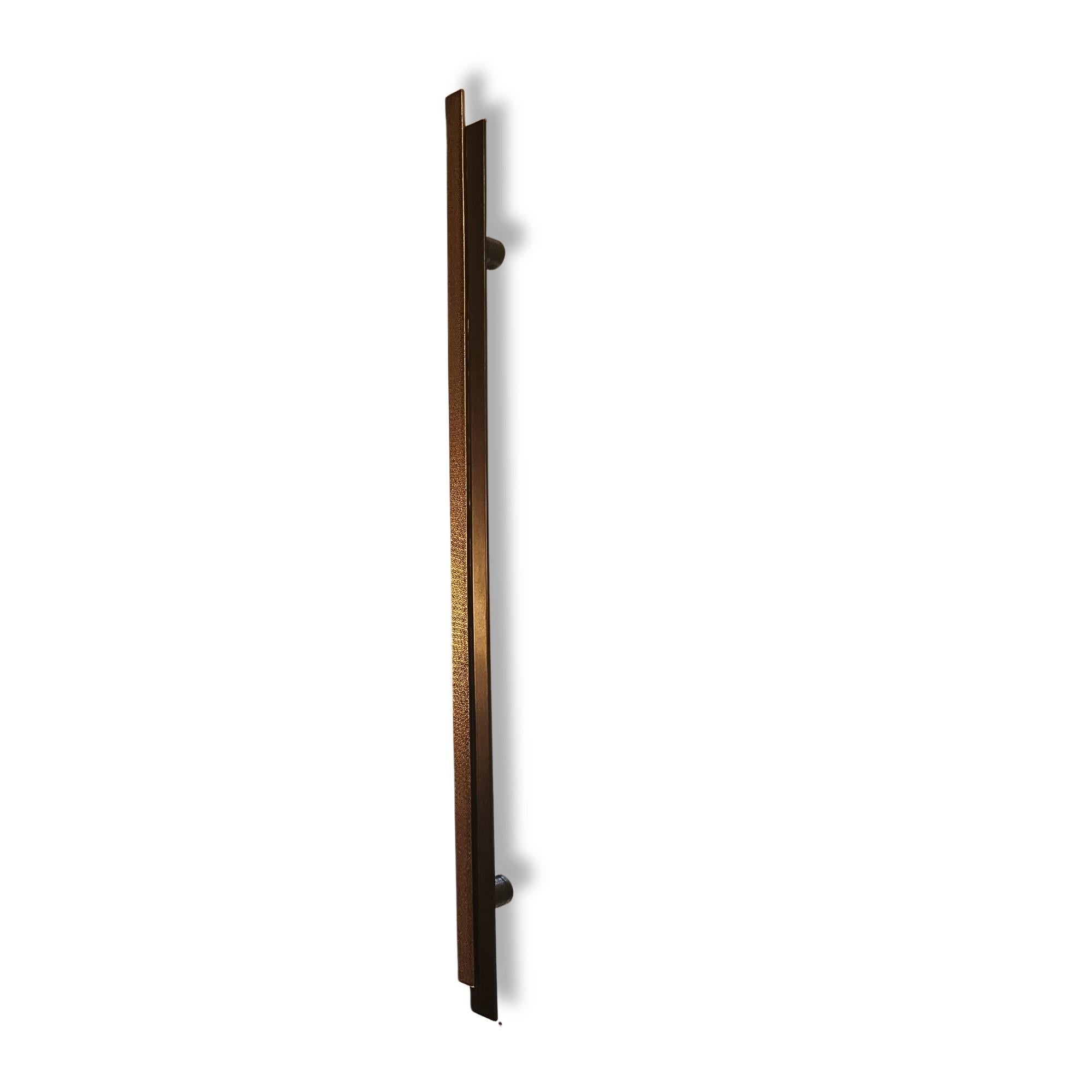 Este tirador de puerta grande de latón macizo encarna una estética refinada y sobria, inspirada en las líneas limpias del estilo Art Déco. Con sus 78 cm de longitud, es ideal para grandes entradas, tanto si se utiliza en interiores como en