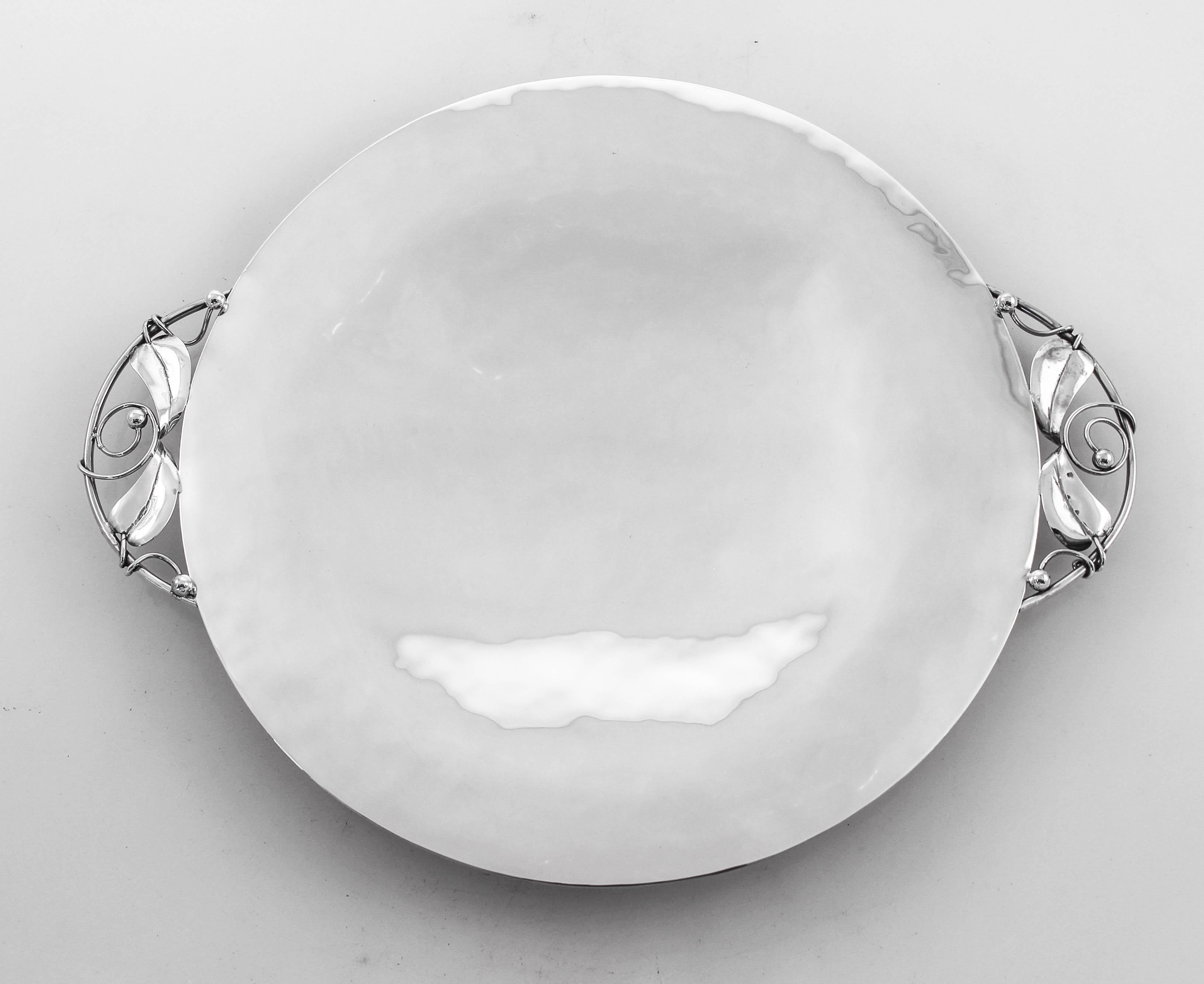 We proudly offer the sterling silver Arts & Crafts dish by Wheelock of Newport, Rhode Island. It is handmade and has a silversmith feel to it; you can tell it was handmade and not mass produced. It stands on four ball-feet and has handles on each