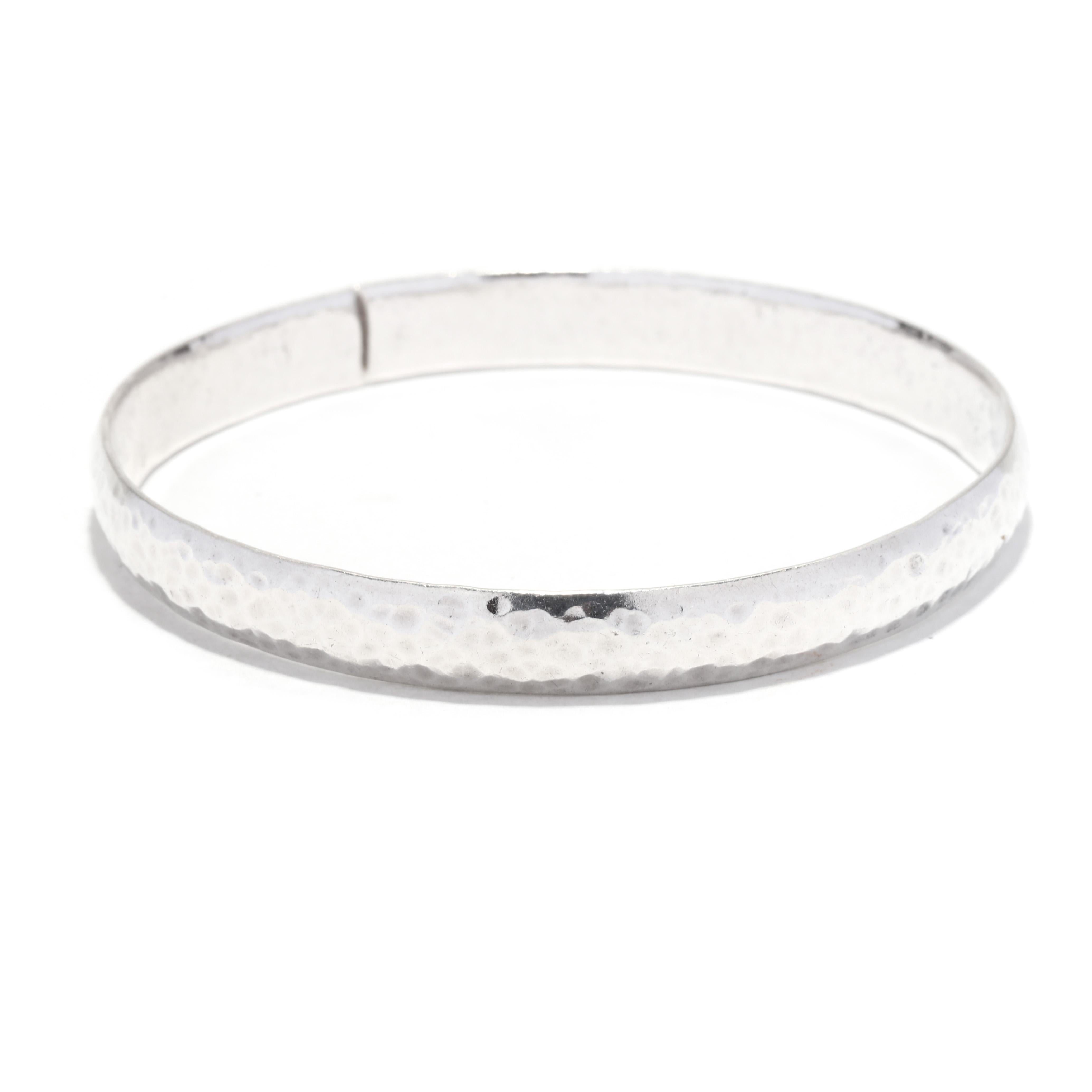 This hammered sterling silver bangle bracelet is a classic accessory that will never go out of style. Its sleek, 7.75-inch design is perfect for everyday wear and adds a sophisticated touch to any outfit. Crafted from high-quality sterling silver,