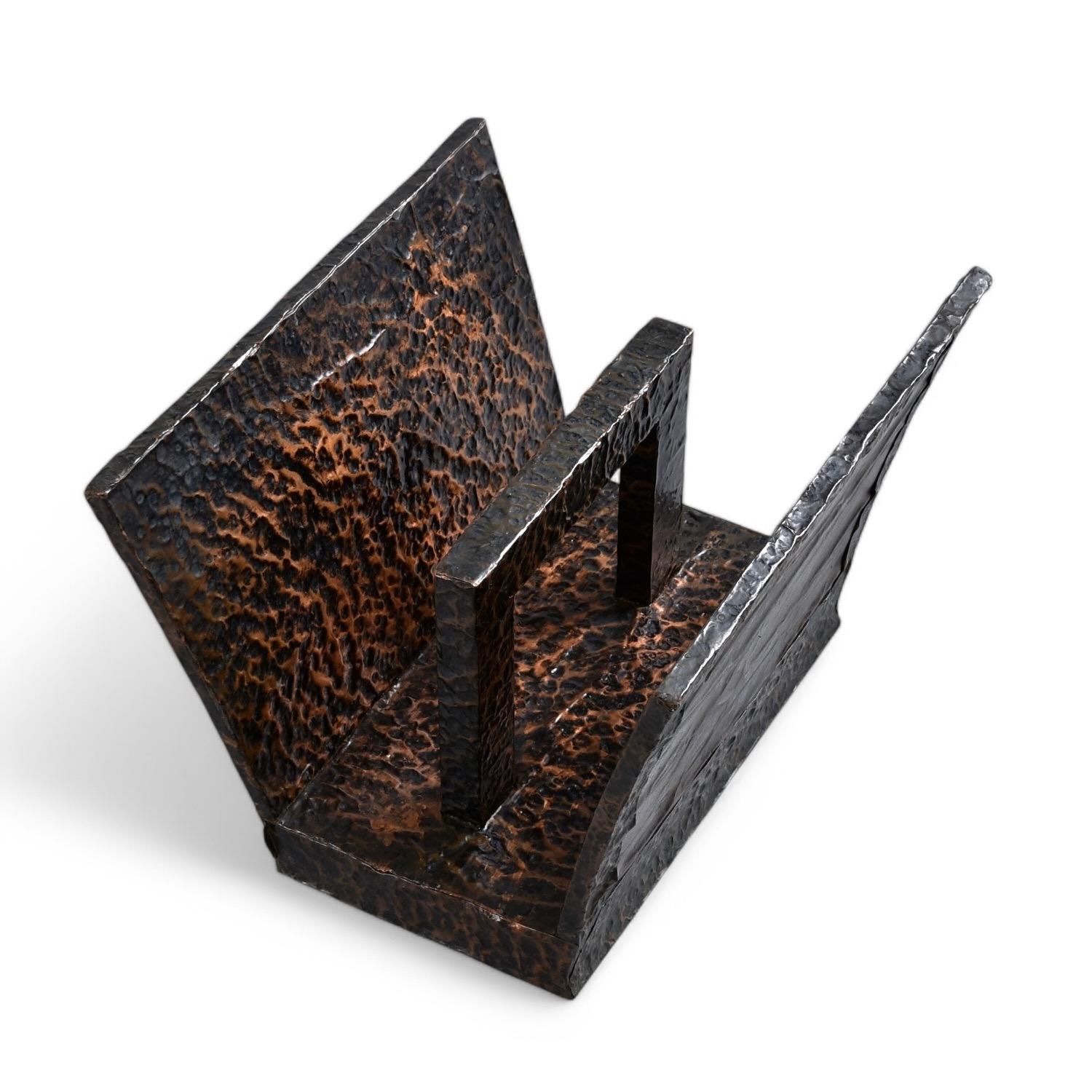 Reich strukturierter schwarzer und kupferfarbener Zeitschriftenständer aus gehämmertem Metall im Vintage-Stil. Die entsteinte und gekräuselte Metalloberfläche zelebriert den handwerklichen Prozess als Gestaltungselement. Kupferfarbene Flächen