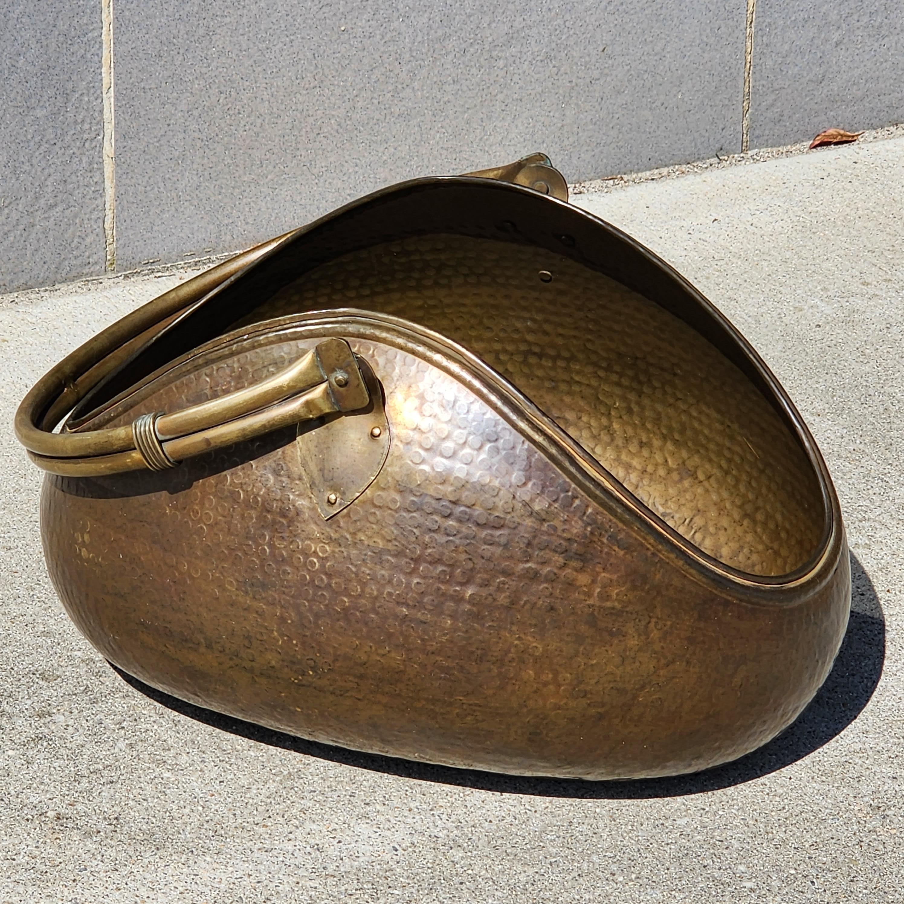 Stunning sculptural hammered brass kindling/small log holder attributed to Egidio Casagrande of Italy circa 1950. The shape is pretty amazing and to make such a a large piece out of hammered brass with no seam line is impressive workmanship.