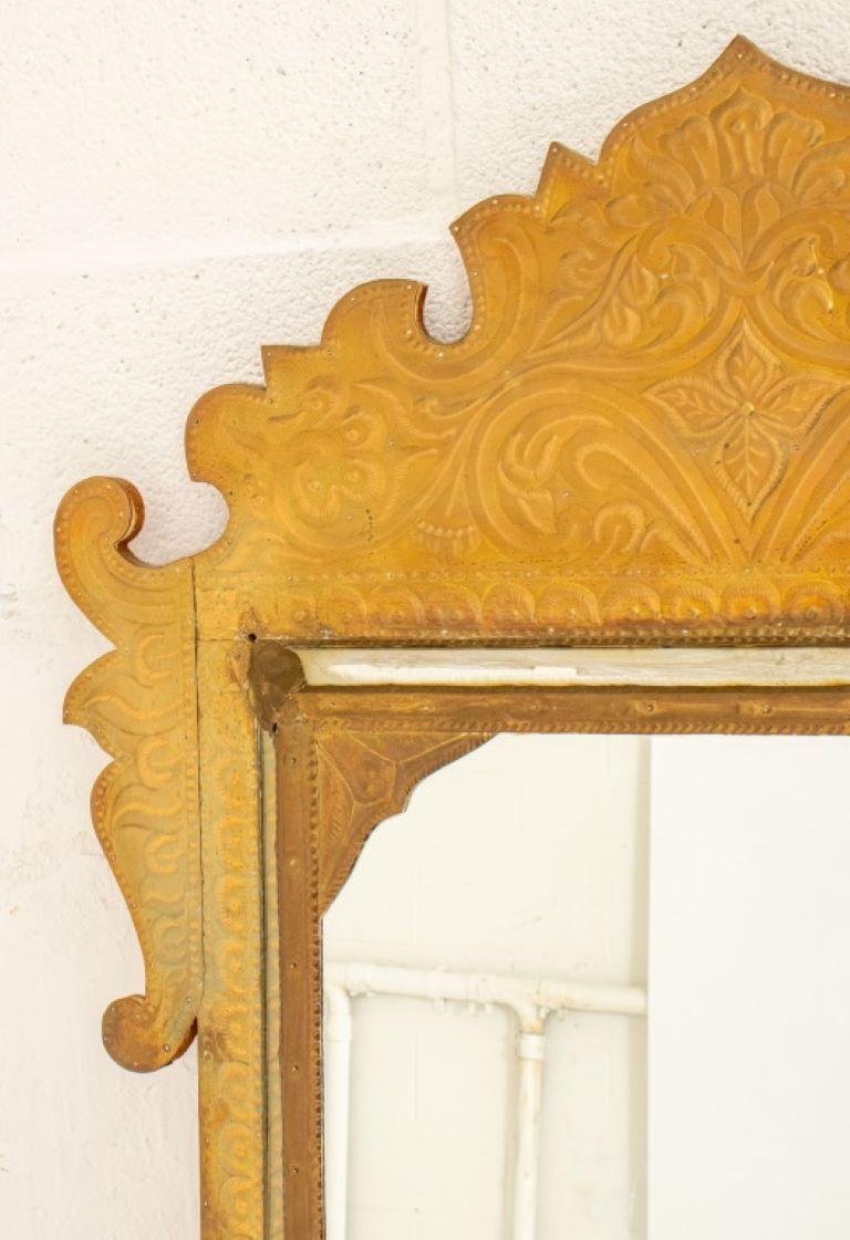 Hammered brass mirror mounted on wood, the frame with scrolling floral design.

Dealer: S138XX