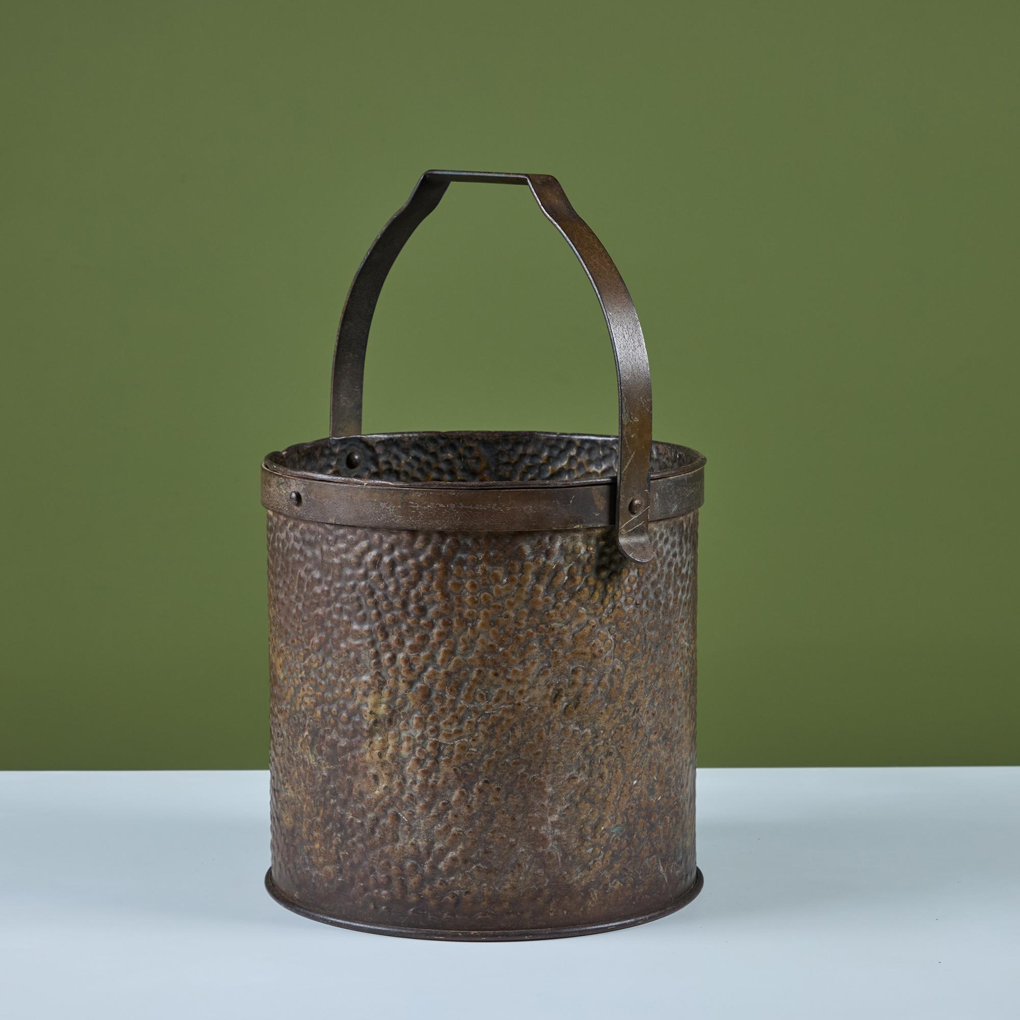 Brass pail with curved handle. This piece features a round perforated body with rivets at both the top and bottom of the pail. It would be a great décor piece or waste basket.

Dimensions
10.5