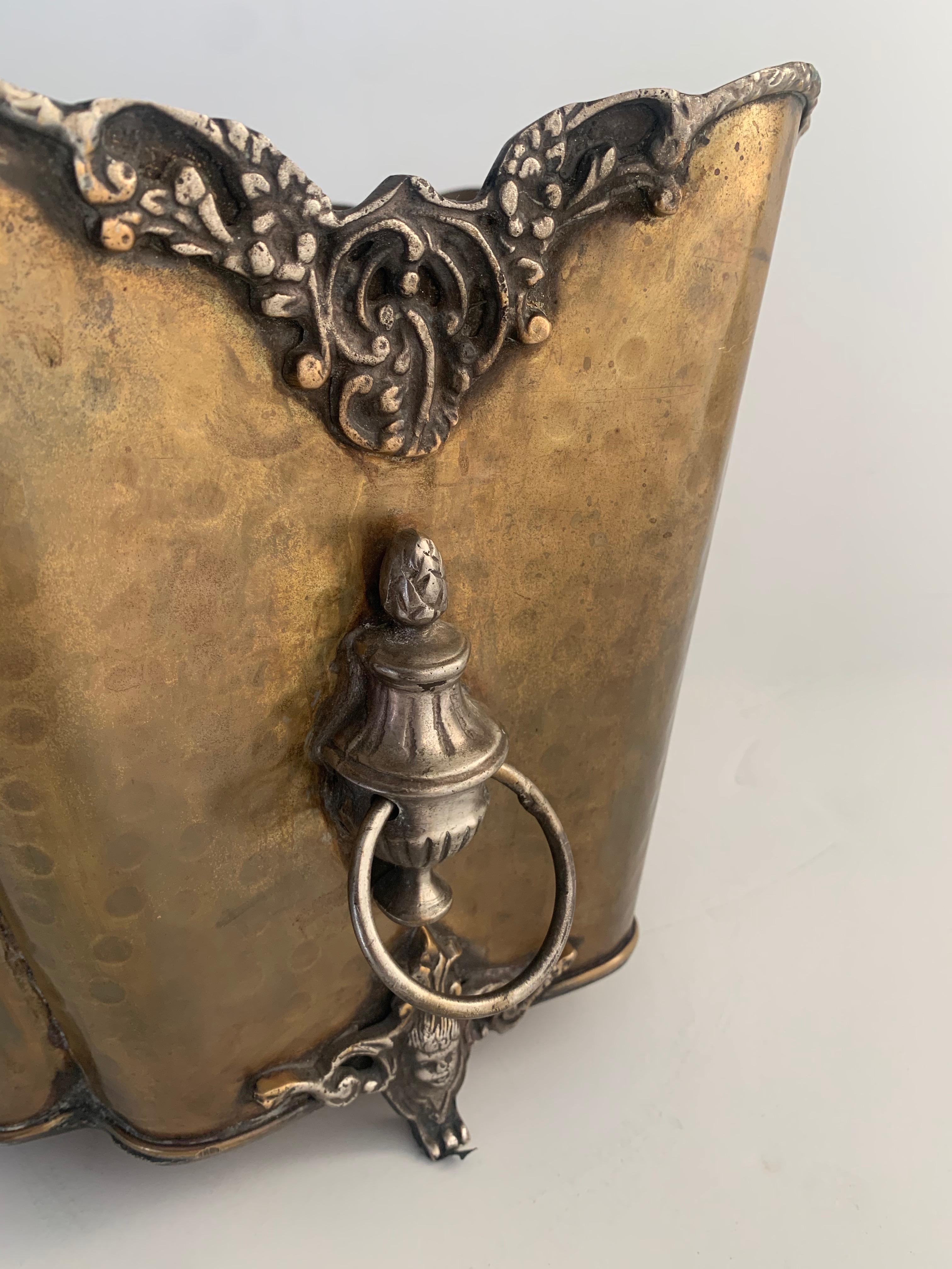 A wonderfully detailed hammered brass planter with lion handles, the piece is perfect for a flowering plant, a center piece or even magazines. The details and claw feet are very nice.