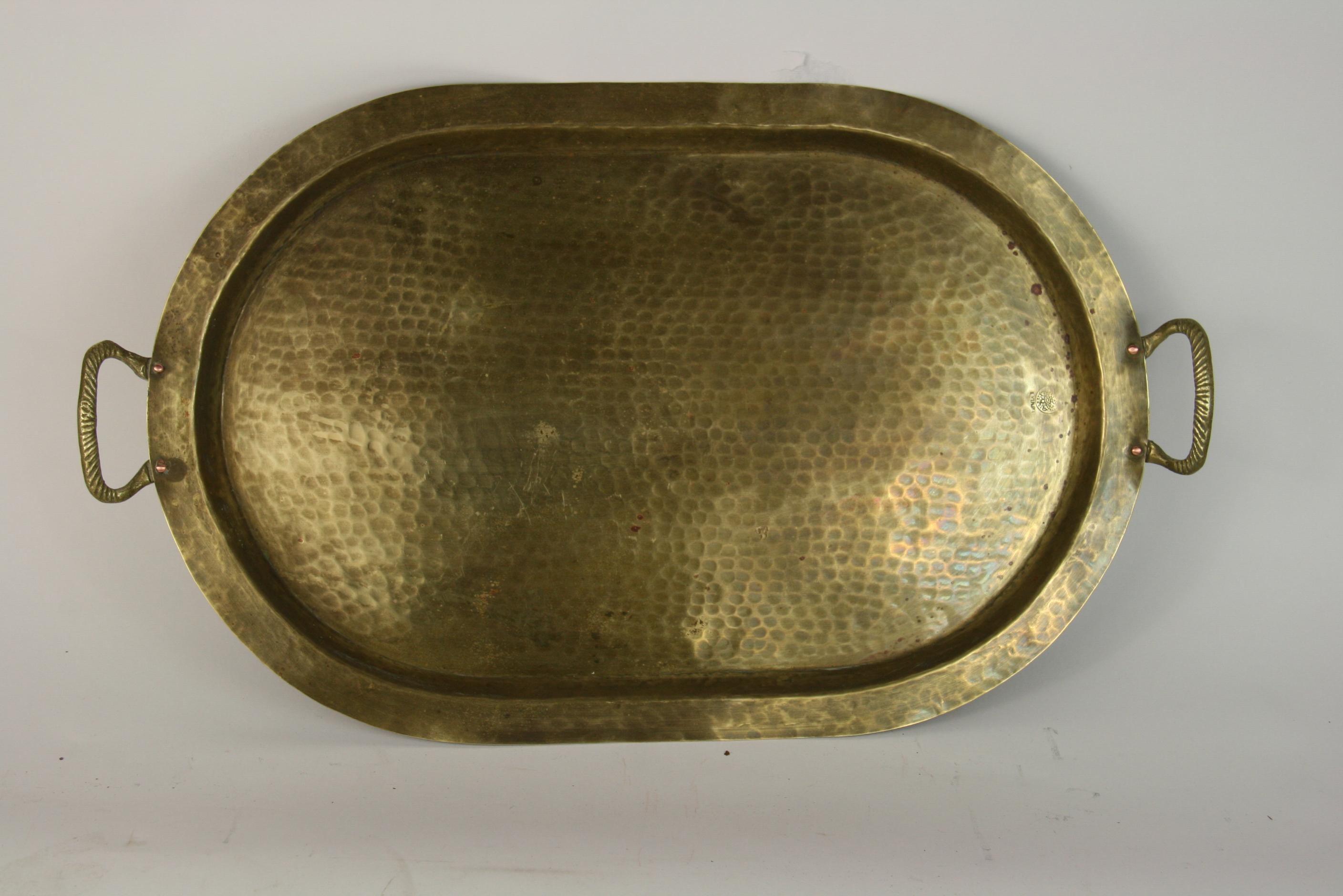 2-314 hammered brass rimmed serving tray. Spiral brass handles with copper rivets 
Winged eagle makers mark (German).
