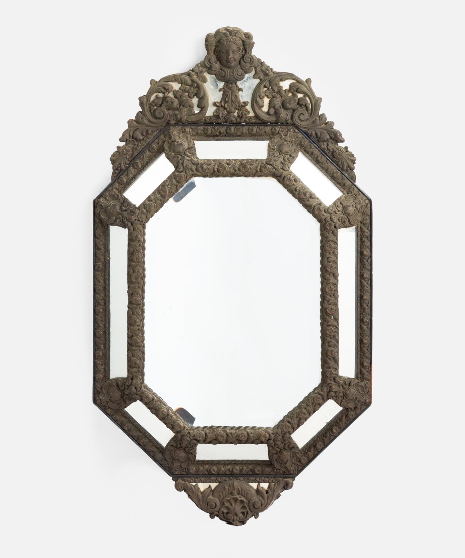 Hammered bronze mirror, Italy, circa 1870.

Dimensional form with highly detailed bronze frame and beveled mirror glass.