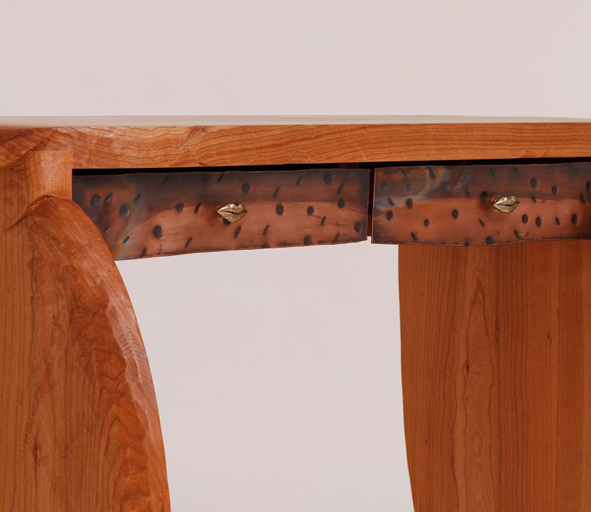 La consolle Roxanne, realizzata in legno di ciliegio massiccio con frontali in rame martellato, è dotata di tiretti in bronzo fuso a forma di labbra realizzati dalla designer di gioielli Pamela Love per Petra Hardware, ma è disponibile anche con