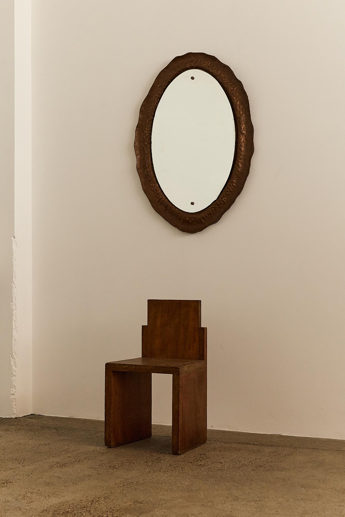 A distinctive oval wall mirror by Italian artist and metalsmith Angelo Bragalini, crafted in the 1960s. The hammered copper frame features an organic, undulating edge with richly textured detailing that beautifully catches the light. Bragalini’s