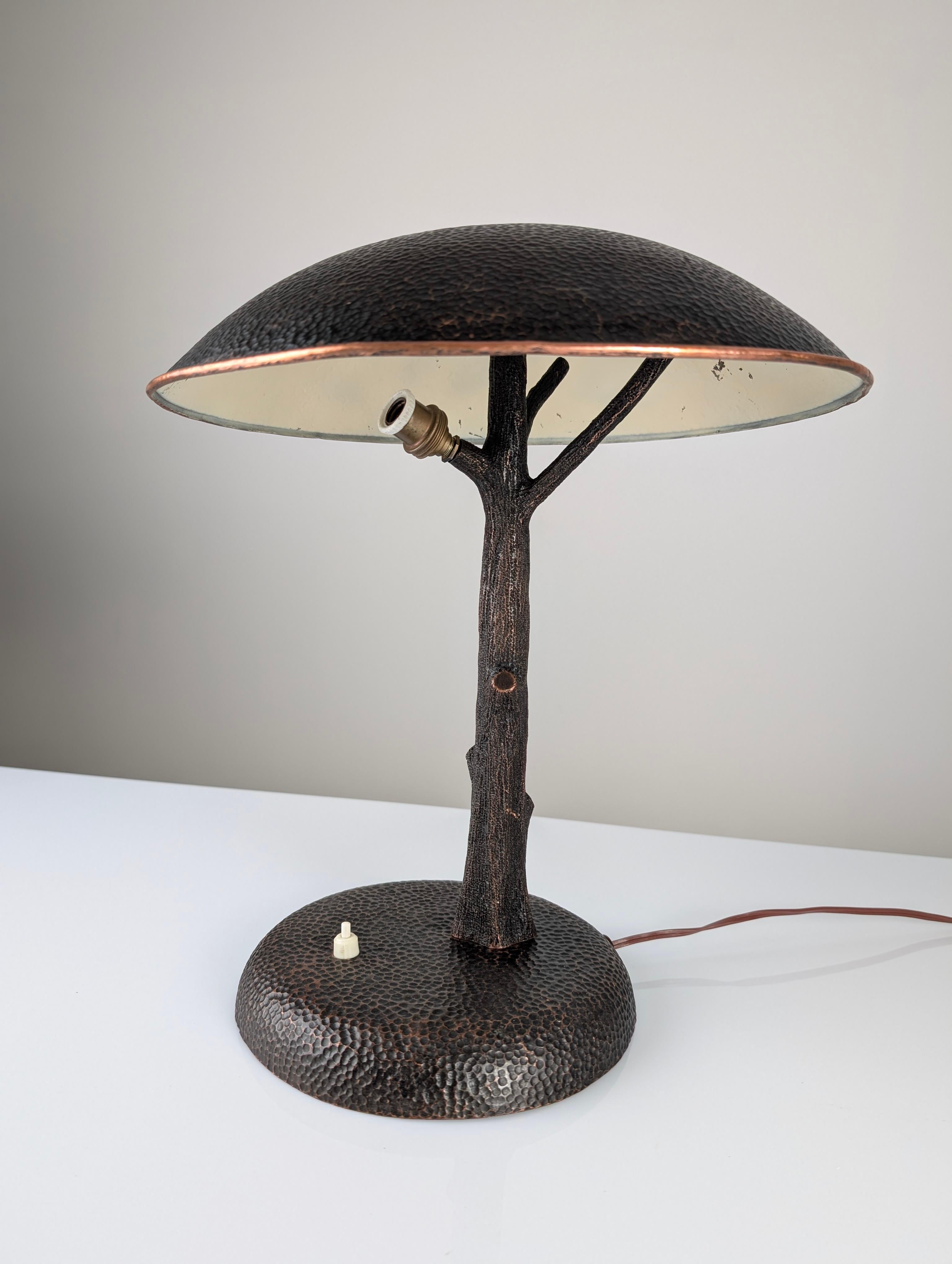 This mid-20th century lamp is a true work of functional art, designed in copper with a design that evokes the shape of a stylized tree. The base, trunk, and shade are meticulously crafted, creating a sculptural piece that uniquely combines nature