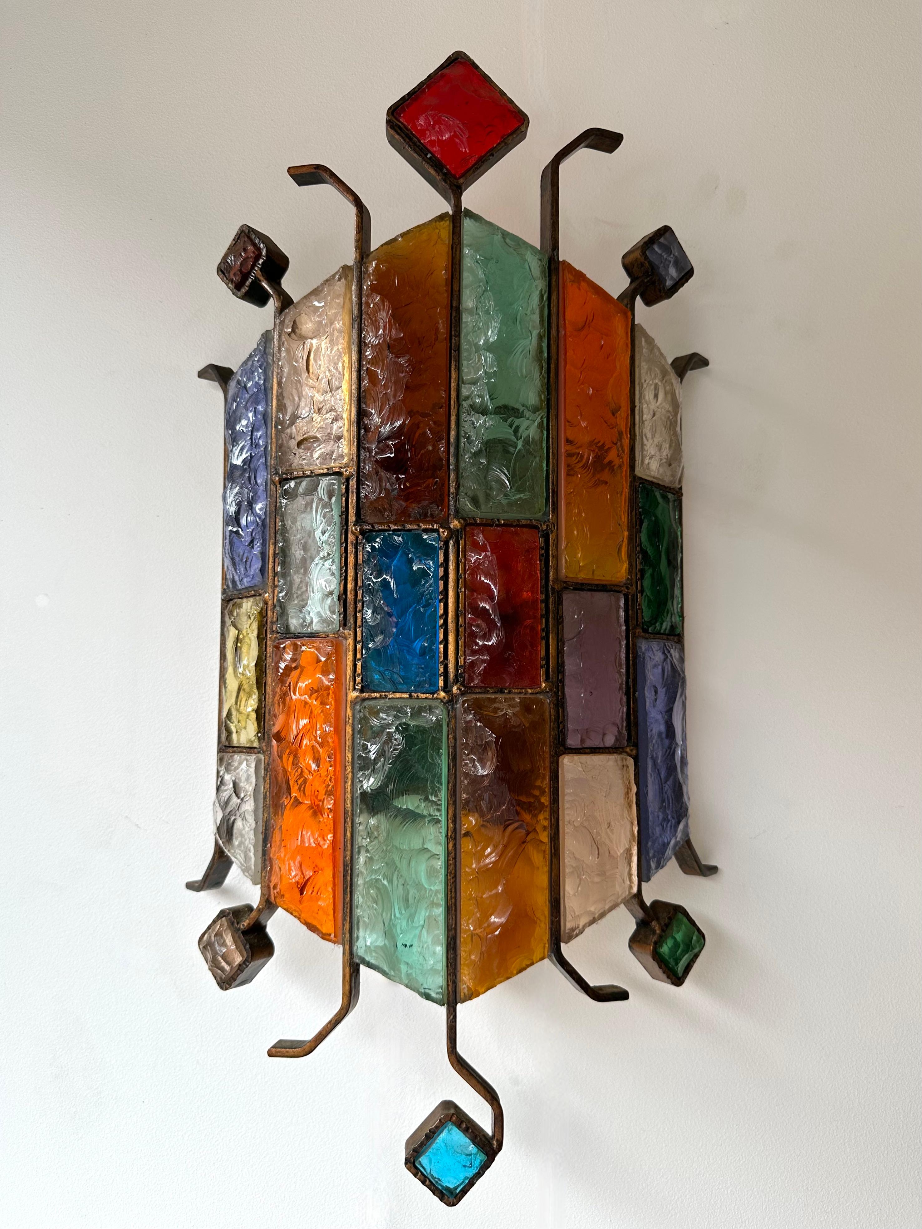 Mid-Century Modern wall lamp light sconce multicolor hammered glass and wrought iron, gilding gold copper patina, by the manufacture Longobard in Verona in a Brutalist style, the concurrent of Biancardi Jordan Arte and Poliarte during the 1970s.