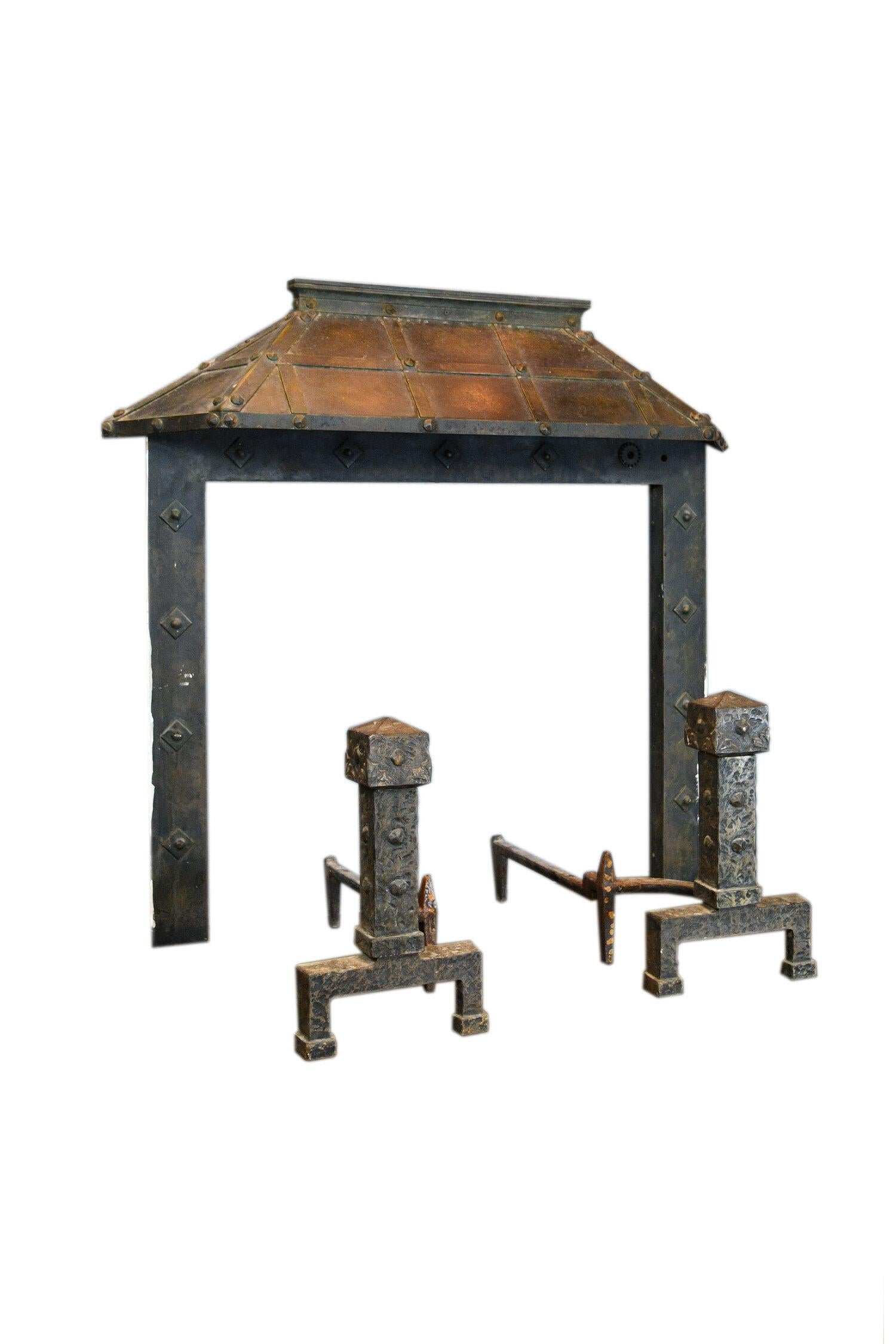 Wonderful iron fireplace set, surround, hood and andirons included. Cast into it are strips of iron and bolts with diamond rivets down the legs and on the andirons. This rustic mantel is fairly flush and would be perfect as a statement piece in a