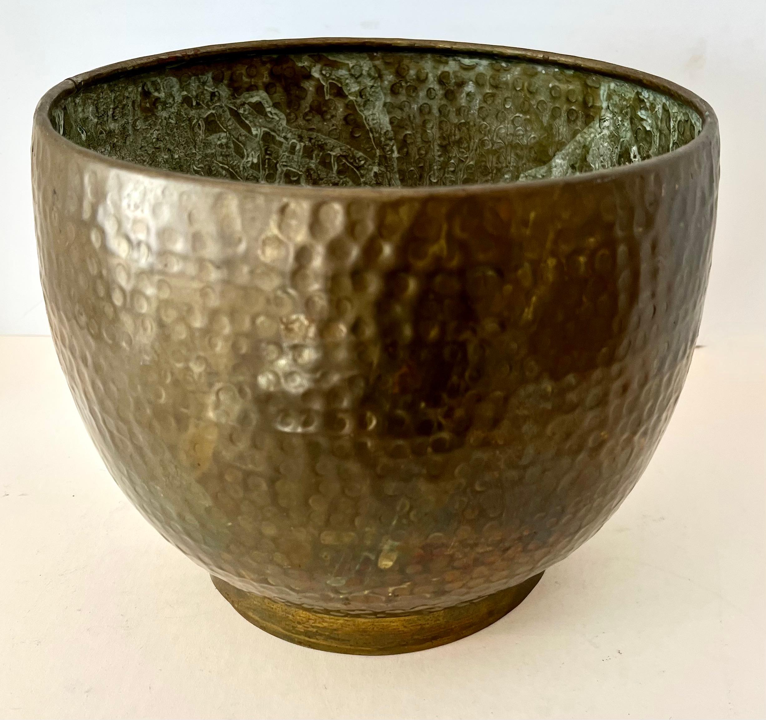 Hammered Cachepot, jardiniere or planter. A lovely patinated brass piece, perfect for your plant or floral arrangement. The piece could also hold other things, like mail or kindling? 

A compliment to many spaces indoor or outdoors. A nice size