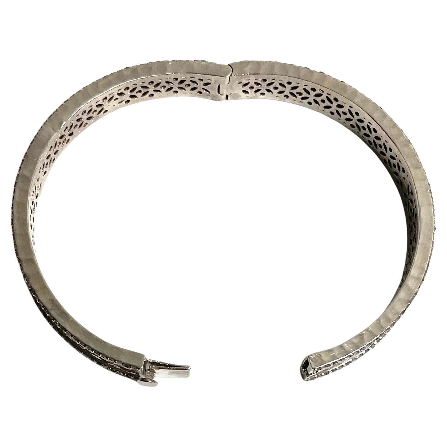 Description
Your elegance interlaced with your edgy style is echoed in this striking sterling silver bangle bracelet embellished with 2.90 carats of pave diamonds. Hammered by hand to create dazzling reflections when catching the light, it is sure