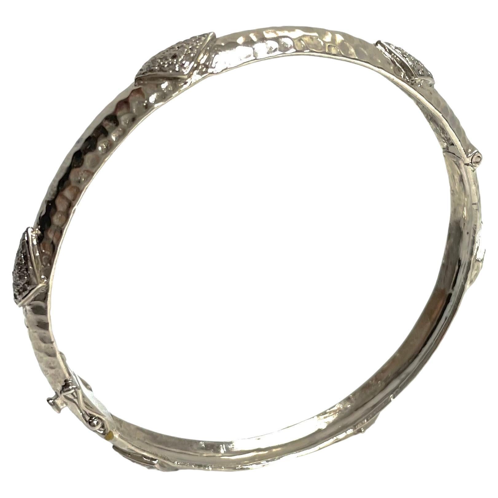Description
Your style comes to life wearing this unique, edgy and timeless sterling silver bracelet. Raised diamond shape appliques totaling 1.20 carats of pave diamonds encircle and embellish this stunning bangle. Artistically hammered by hand to