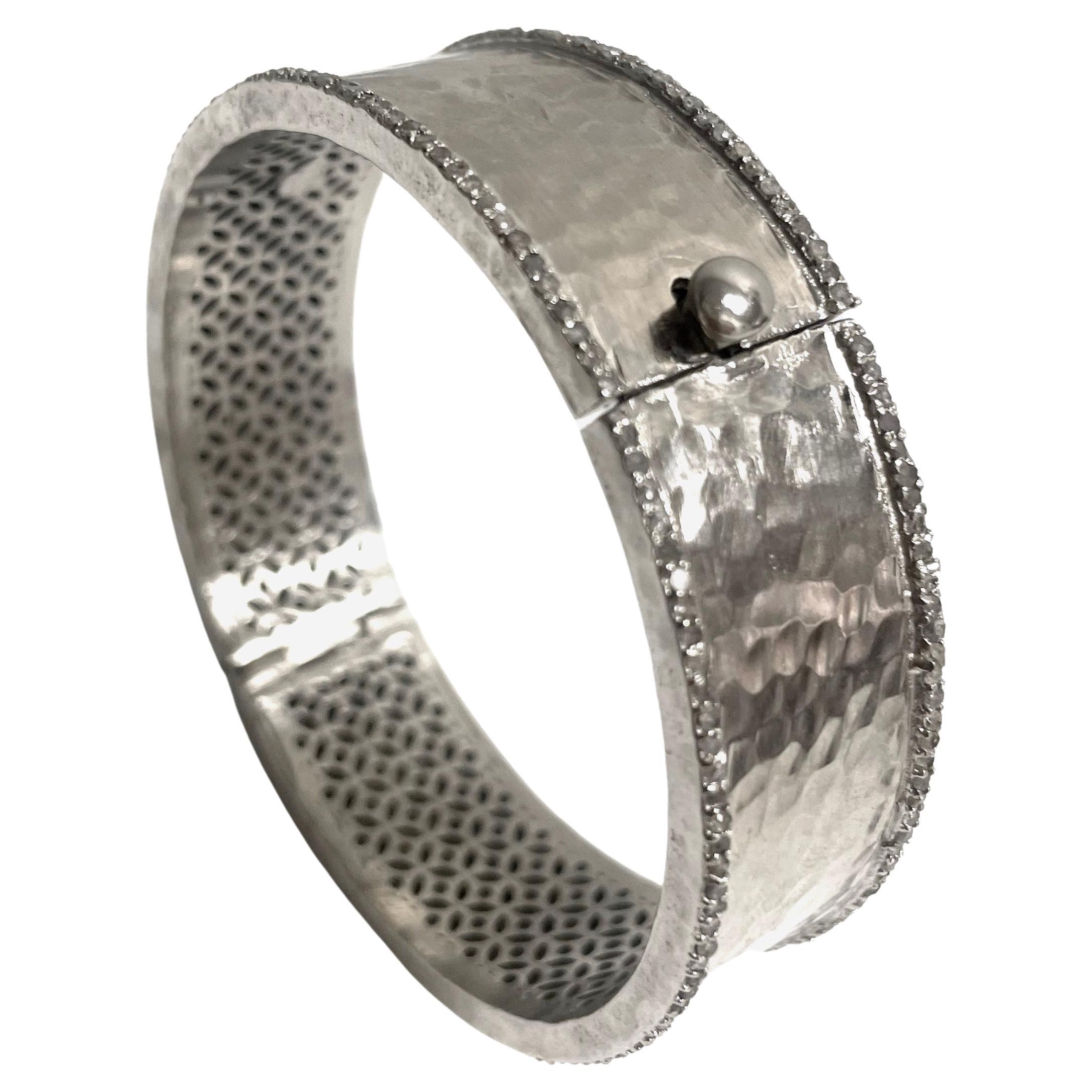 Description
Your elegance interlaced with your edgy style is echoed in this striking sterling silver bangle bracelet embellished with 6.30 carats of pave diamonds. Hammered by hand to create dazzling reflections when catching the light, it is sure