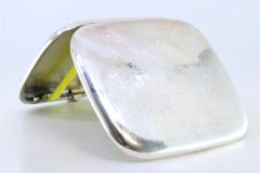 Hammered silver cigarette case with hinged lid and two ribbons inside