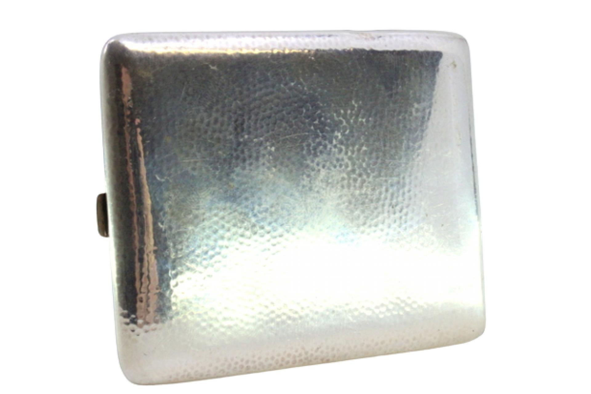 Description: Hammered silver cigarette case with hinged lid. Metal: Silver. Origin: German. Brand: WR. Weight: 98.49 grams. Dimensions: 9.5cmx8cm. Content: 800/1000. Assay Mark: Yes. Additional information: Signs of use