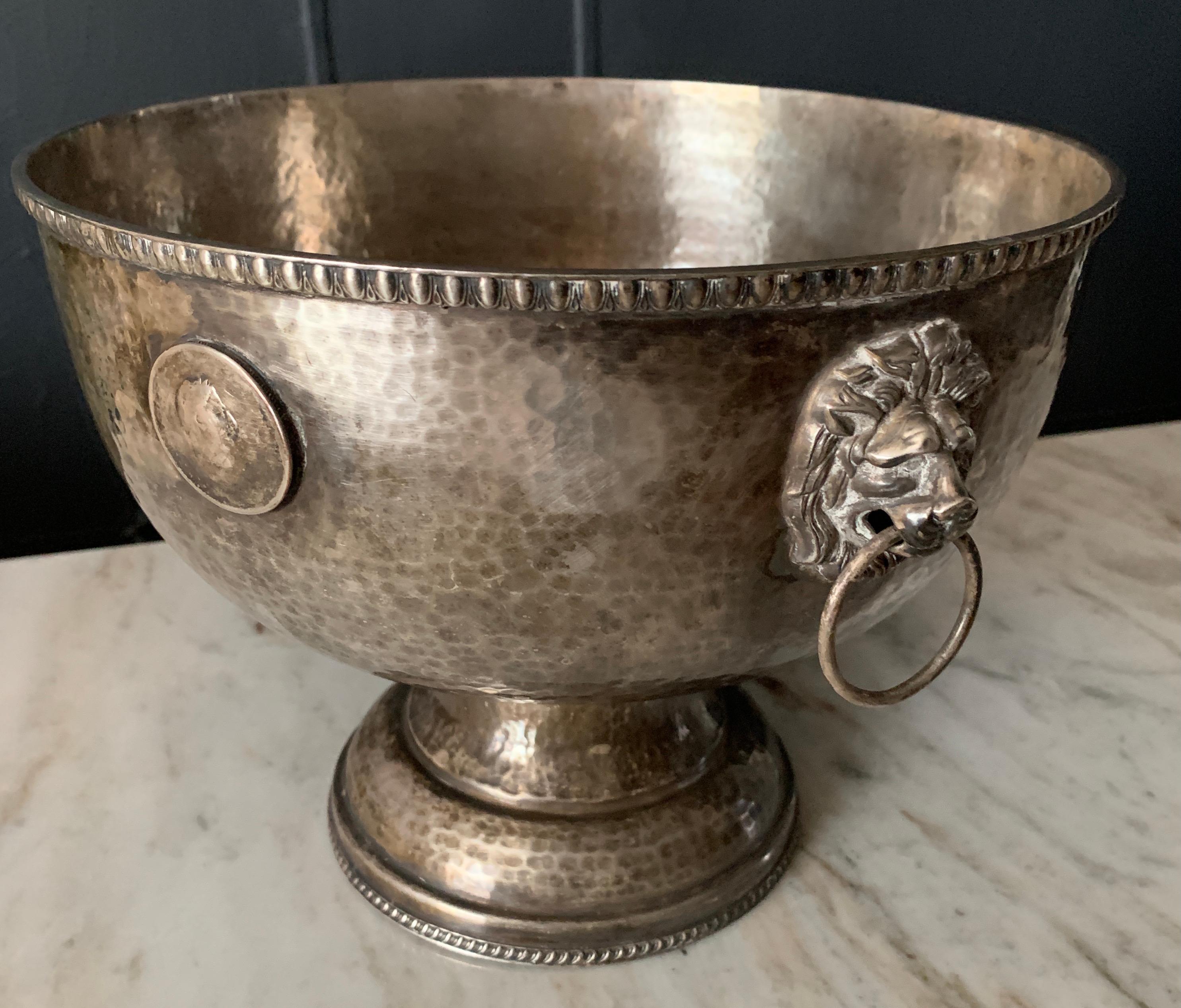 A wonderful hammered silver bowl with medallion details and lion head handles - the perfect size to be used for a serving piece, center piece, fruit bowl or catch all for mail, flowers.