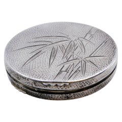 Hammered silver toiletry box with floral motifs and a gold-colored mirror inside