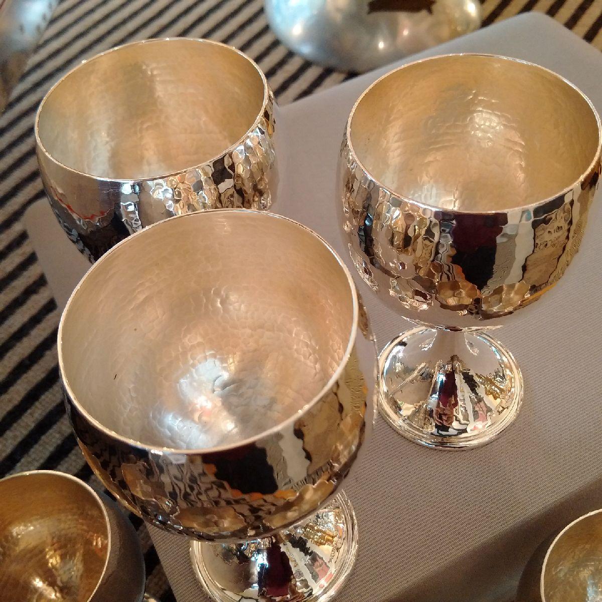 Buccellati, Italy.

A set of eight handmade Sterling silver stemmed Champagne or wine goblets by Buccellati, each goblet with a plain, swept foot and the bowl in a hammered or martelé finish, in pristine and seemingly unused condition. Each