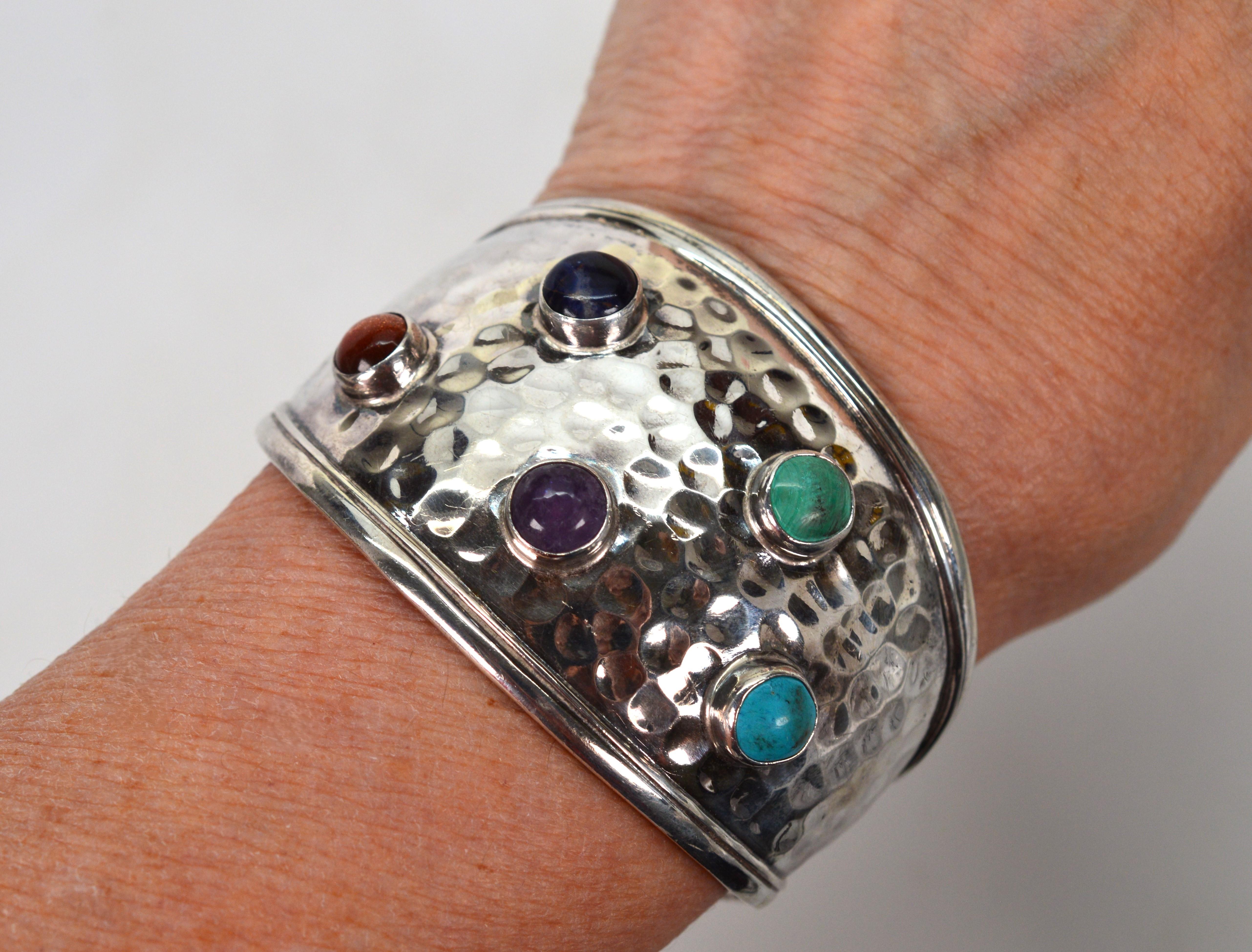 Vintage era, artisan made. Hand-hammered sterling silver gives this generously wide cuff bracelet its desirable textured finish.
Contoured to hug the wrist and at a width of  1-3/4 inches at the widest point in the front position, the bracelet is
