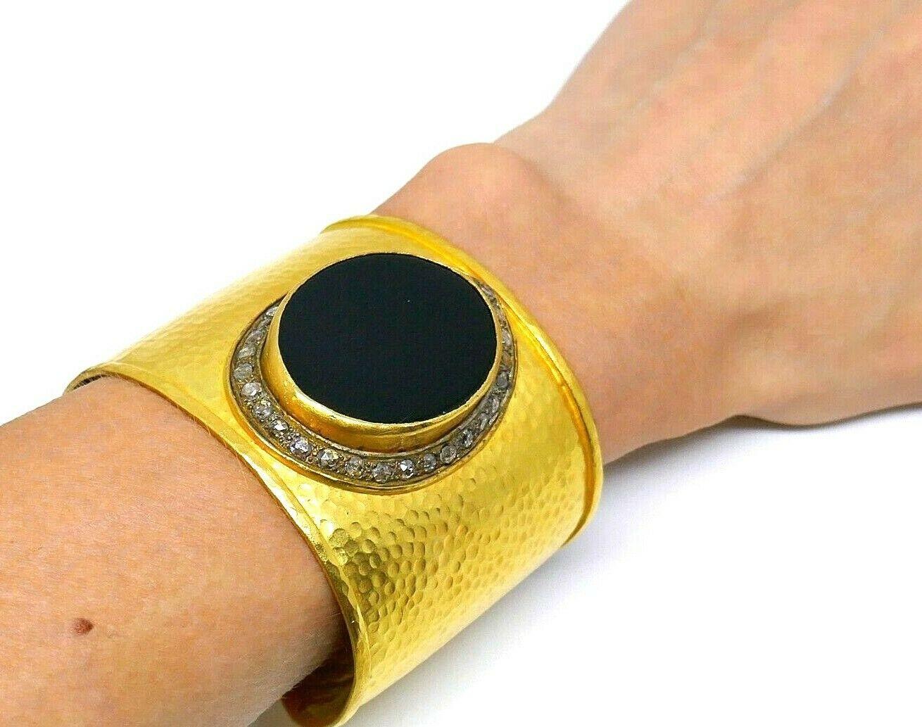 Wide impressive hammered yellow gold cuff bracelet  featuring onyx surrounded by rose cut diamonds.
Measurements: inner circumference is 6 inches, width is 2 inches. Intended for small to medium-sized wrists.
Weight is 74.9 grams

