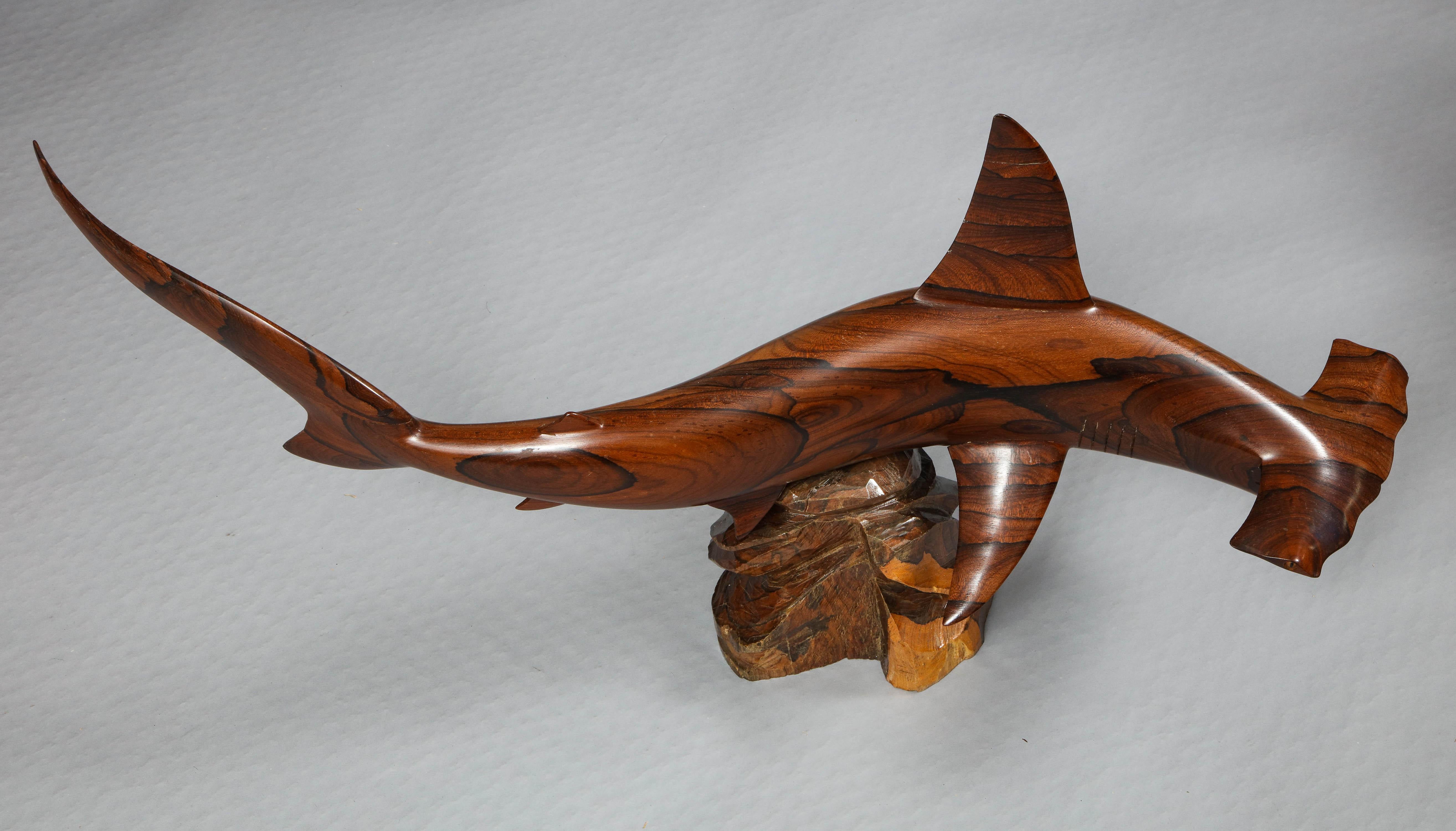 Very fine carved hammerhead shark executed in vividly grained exotic hardwood on naturalistic stand.
