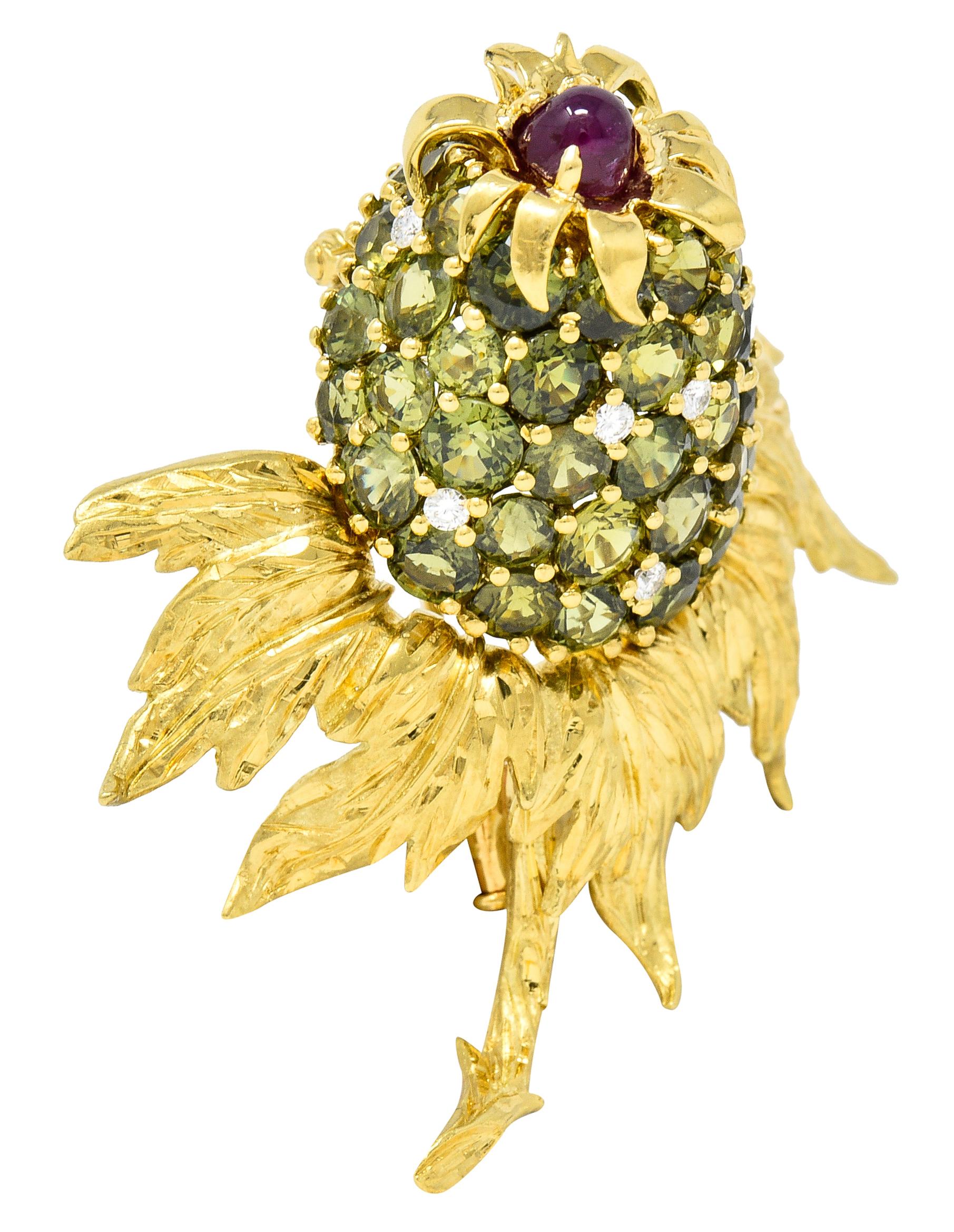 Statement brooch is designed as a stylized thistle flower. With highly rendered and dynamic foliate - brightly polished, contrasting, engraved finishes. Flower is comprised of pavè set round cut green sapphires weighing in total approximately 17.85