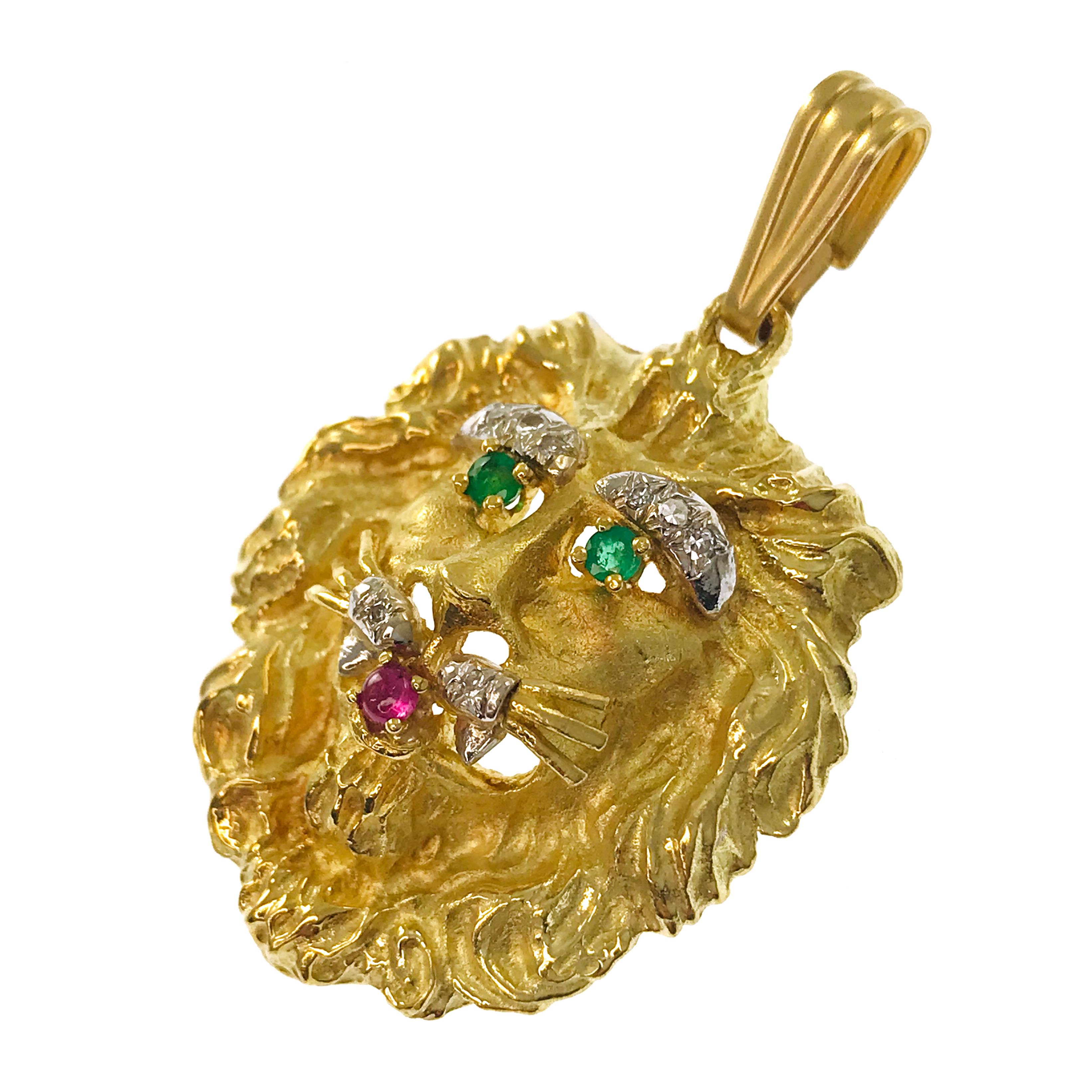 Vintage Hammerman Brothers 18 Karat Lion Pendant. Bold design with Emerald round eyes, a round Ruby tongue cabochon, and eight diamond accents. Eight 2mm diamonds for a total carat weight of 0.24ctw, two 2.25mm Emeralds for a total carat weight