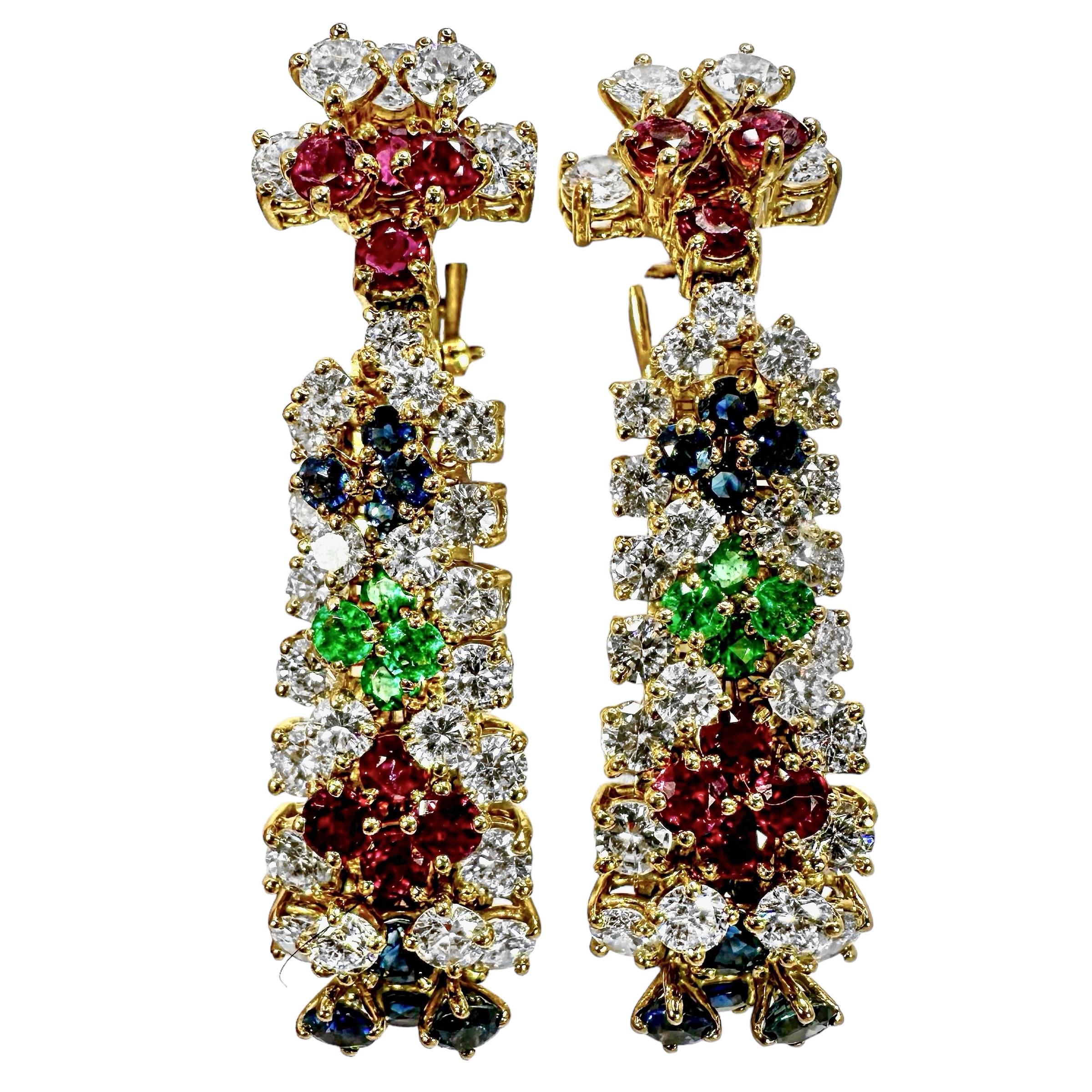 Ein atemberaubendes und vielseitiges Paar Ohrringe von 2 Zoll Länge, besetzt mit Diamanten, Smaragden, Rubinen und Saphiren. Die aus 18-karätigem Gold gefertigten Ohrringe sind oben und an den Seiten mit Diamanten besetzt. In der Mitte der Ohrringe