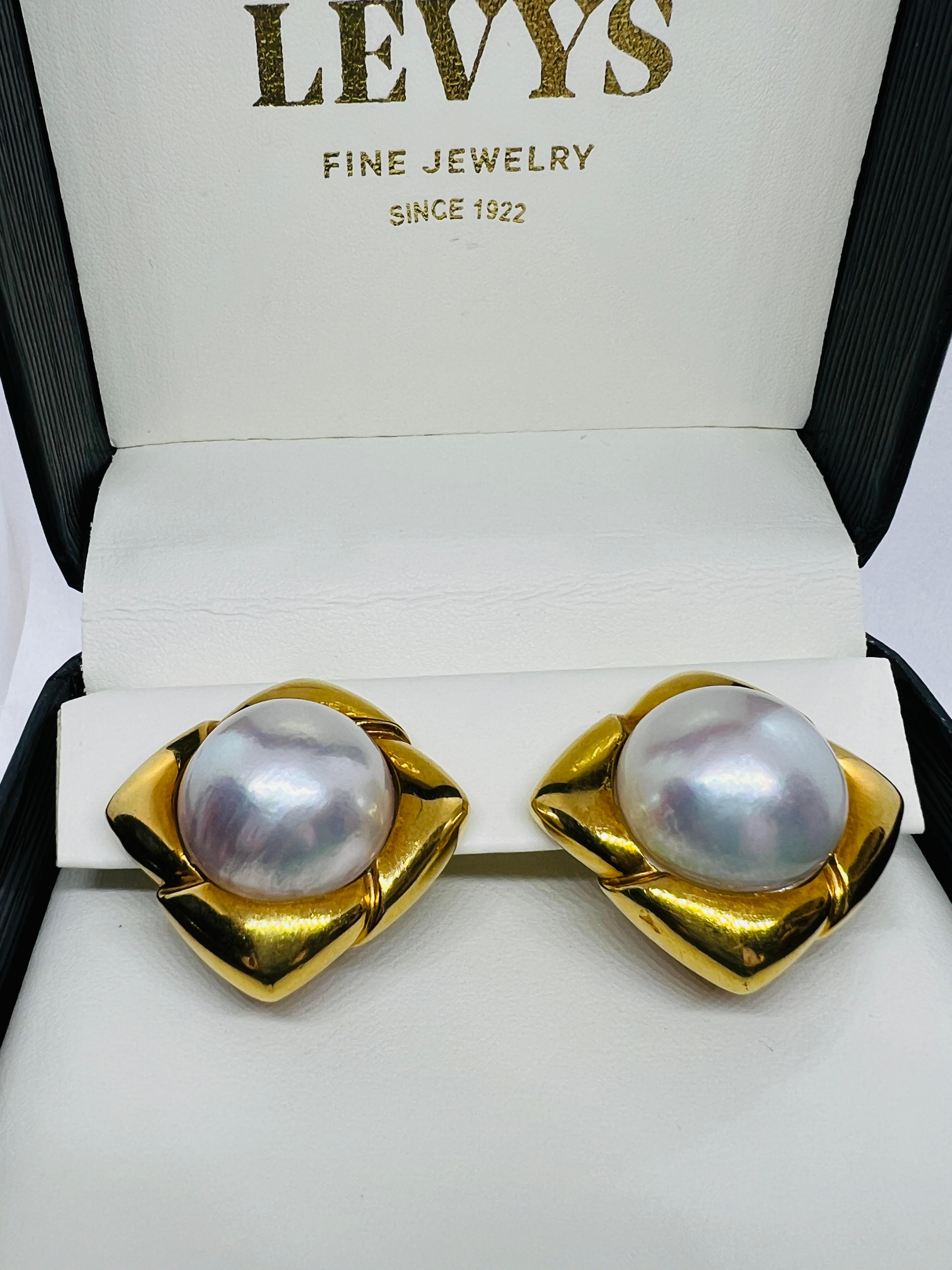 Gorgeous Hammerman Brothers Designer Earrings. These are made in 18K yellow gold and feature two stunning 8 carat More Pearls at the center. They measure one inch square and weigh 35.4 grams. Please note they do not sit square on the ear. They sit
