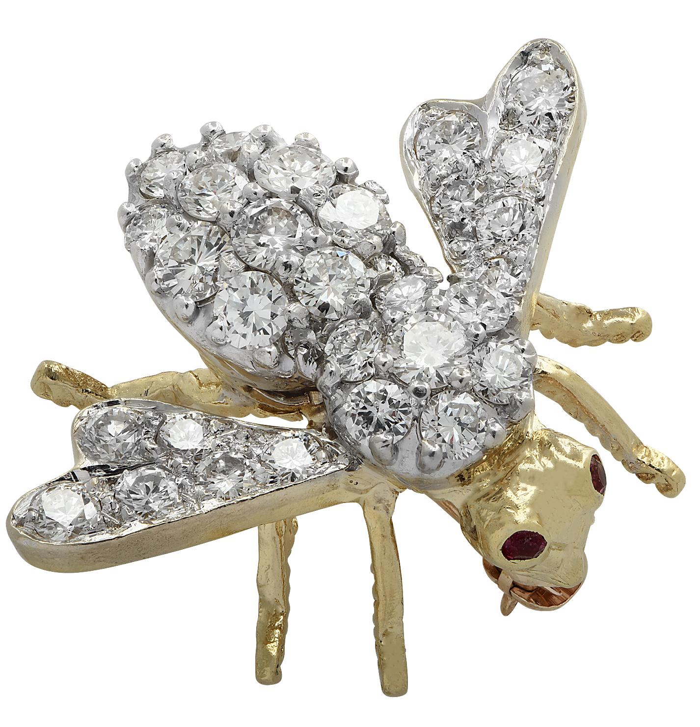 Enchanting David Hammerman bee brooch pin crafted in 18 karat white and yellow gold featuring 31 round brilliant cut diamonds weighing approximately 1.75 carats total, G color, VS clarity with two ruby eyes. The body and wings of the bee are