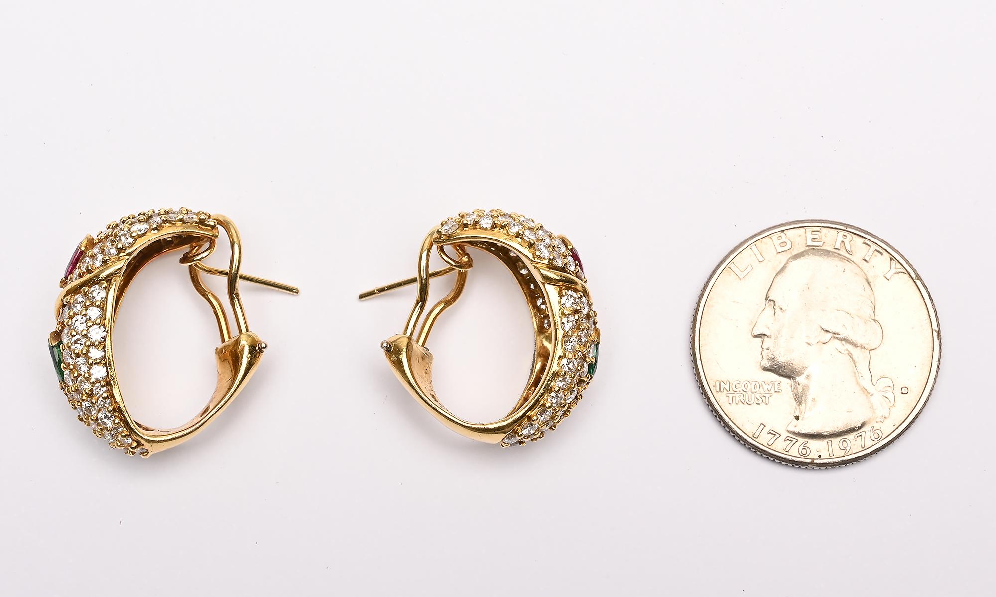 Elegant diamond hoop earrings by Hammerman Brothers. In addition to 3.3 carats of diamonds, each earring has a pear shaped ruby and emerald.
The backs of the earrings are intentionally at an angle to better hug the face. Backs are posts and clips.