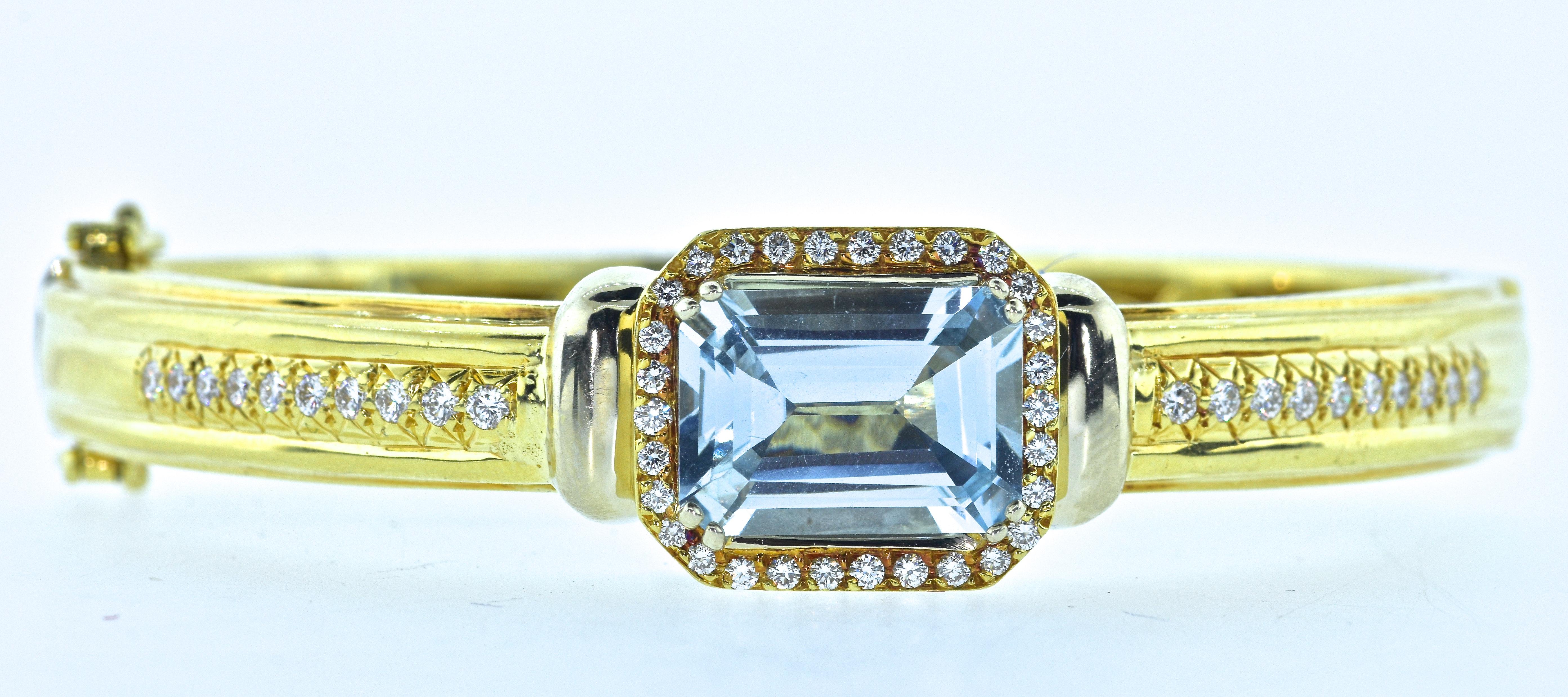 Hammerman Brothers diamond and aquamarine 18K yellow gold bangle bracelet.  The center natural bright blue aquamarine is emerald cut with dimensions of 13.96 mm. by 10.0 mm. by 6.2 mm., and estimated to weigh approximately 6.0 cts.  This aquamarine