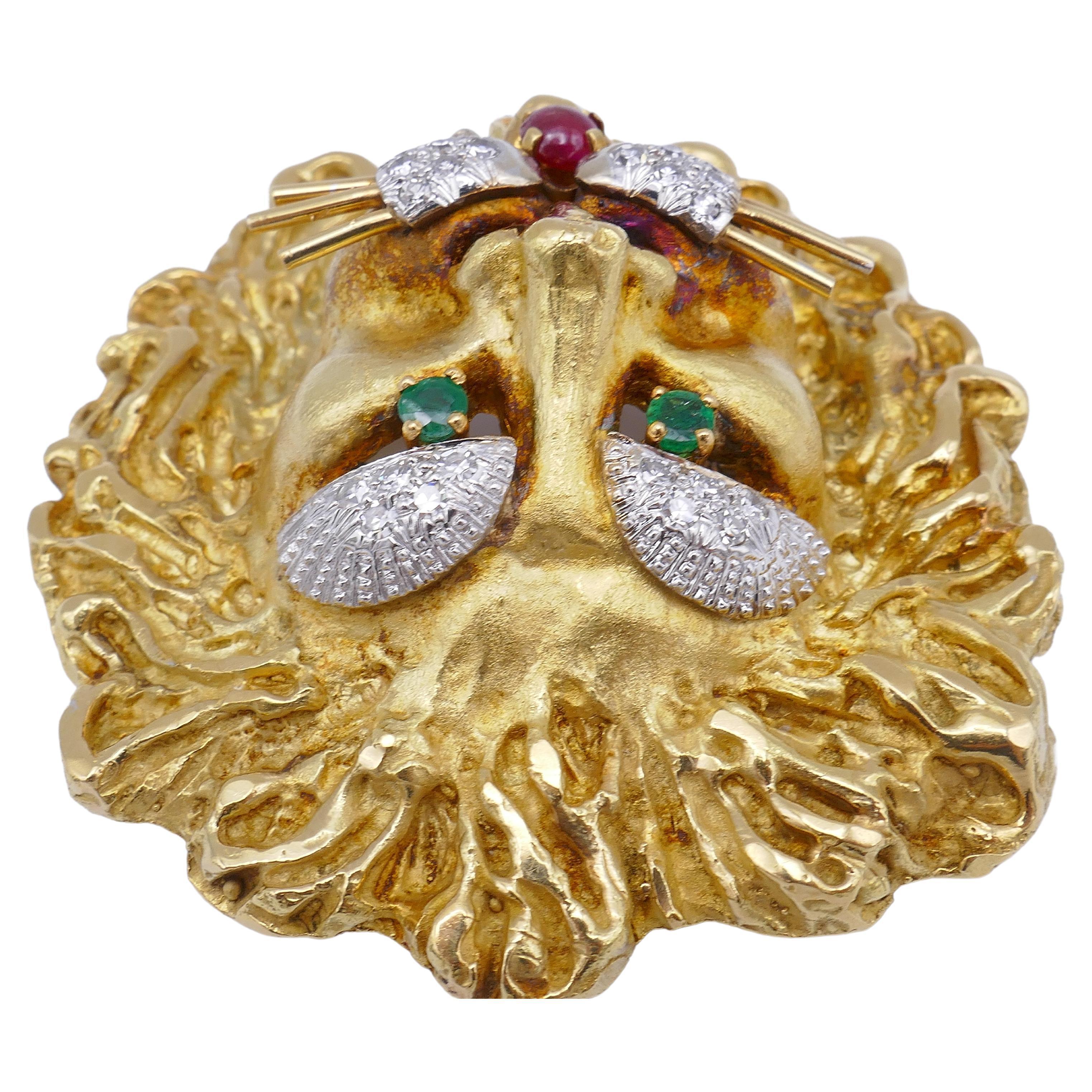 A gorgeous Leo pendant by Hammerman Brothers made of 18k gold, features diamonds and colored gemstones.
The pendant is designed as a head of lion with a mane. The latter is crafted of textured gold, and the face has a matte finish. 
The piece