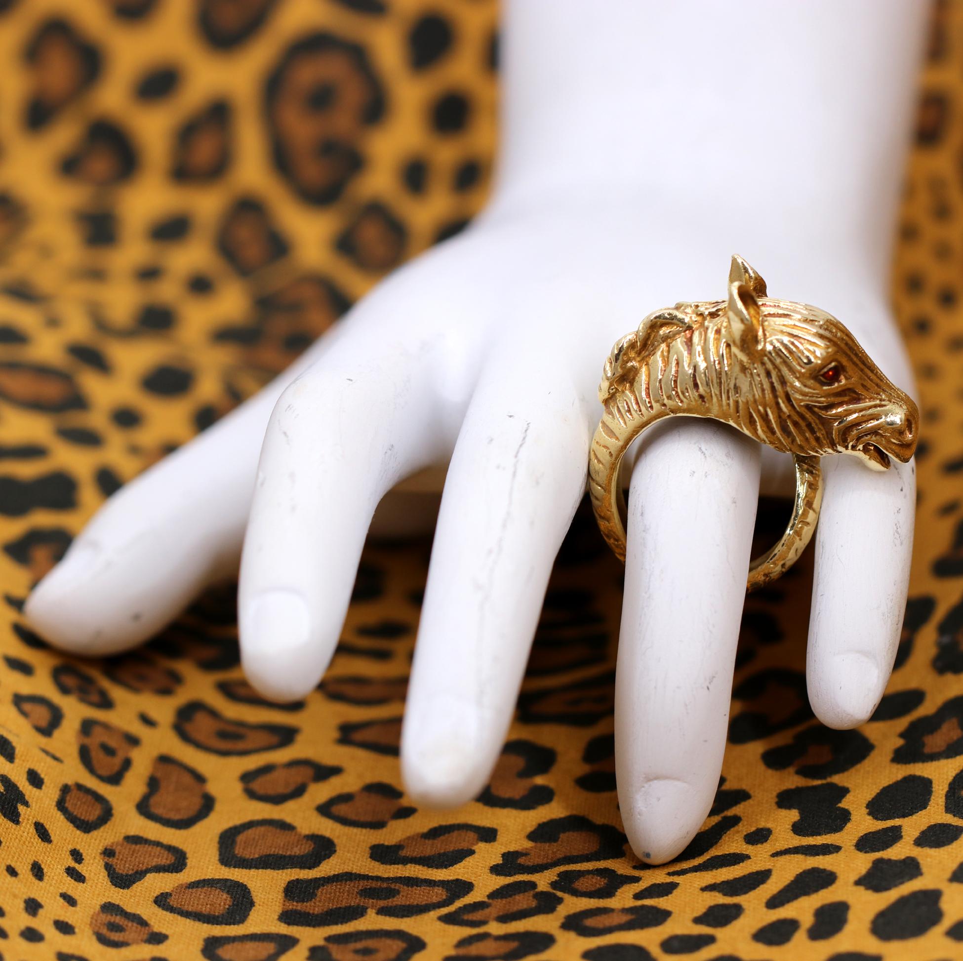 A stylish ring in 18K yellow gold in the form of a zebra, with its tail wrapping around to make the outline. Beautifully detailed with engraved stripes, this ring measures 2/3 of an inch wide. With a touch of enamel adding color to this creatures