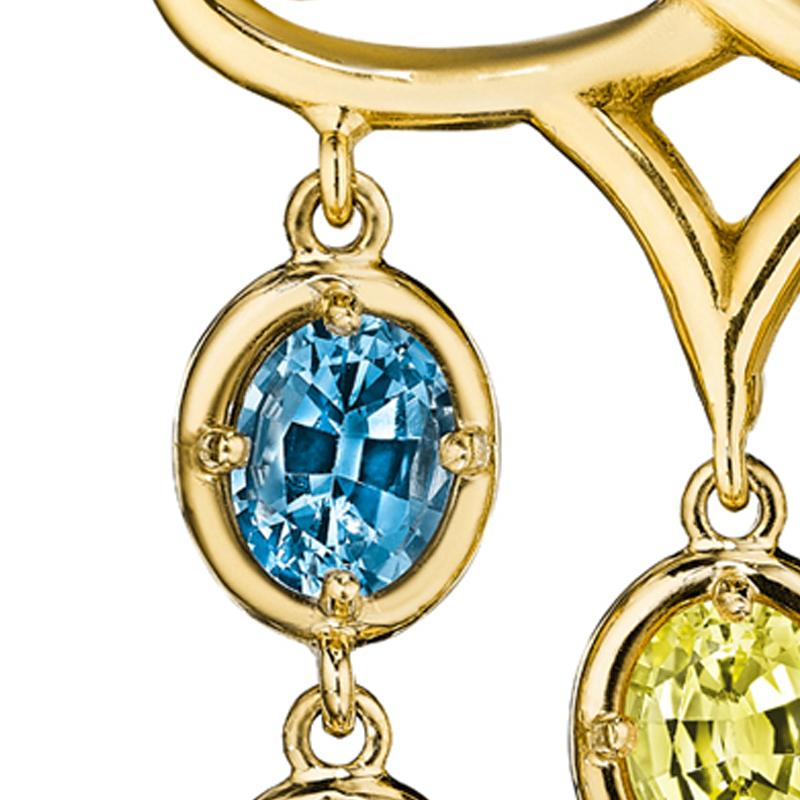 A cascade of multi-color sapphires drip from ornate scroll work motifs, each hue exquisitely balanced to complement and enhance the palette. 24 glistening stones each carry a story as unique as the colors themselves, suspended to add movement and