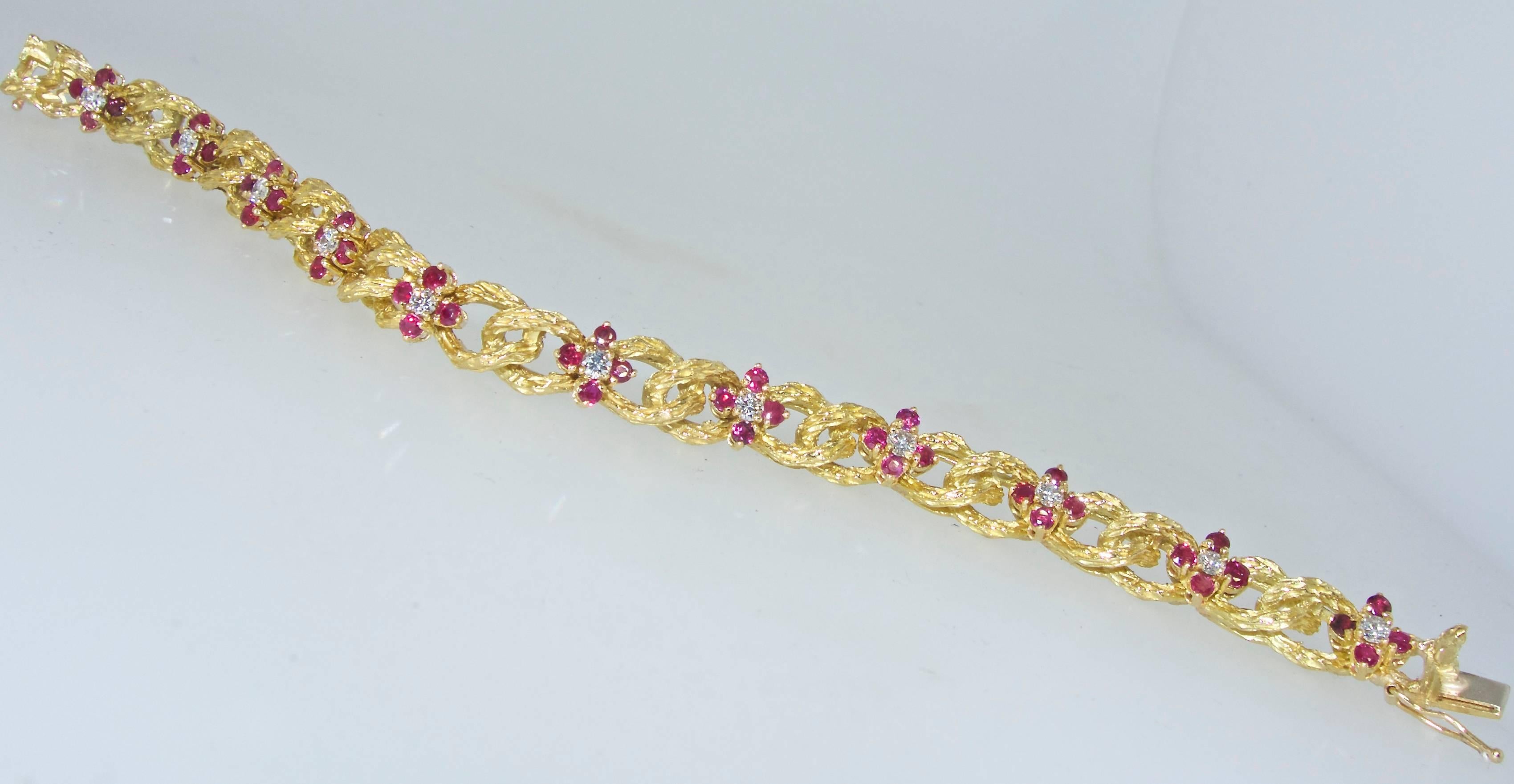  18K yellow gold bracelet with 44 natural fine Rubies, weighing totally approximately 1.32 cts. and 11 fine white diamonds weighing totally approximately .88 cts.  This contemporary charming flower motif bracelet is 7.25 inches long and very well