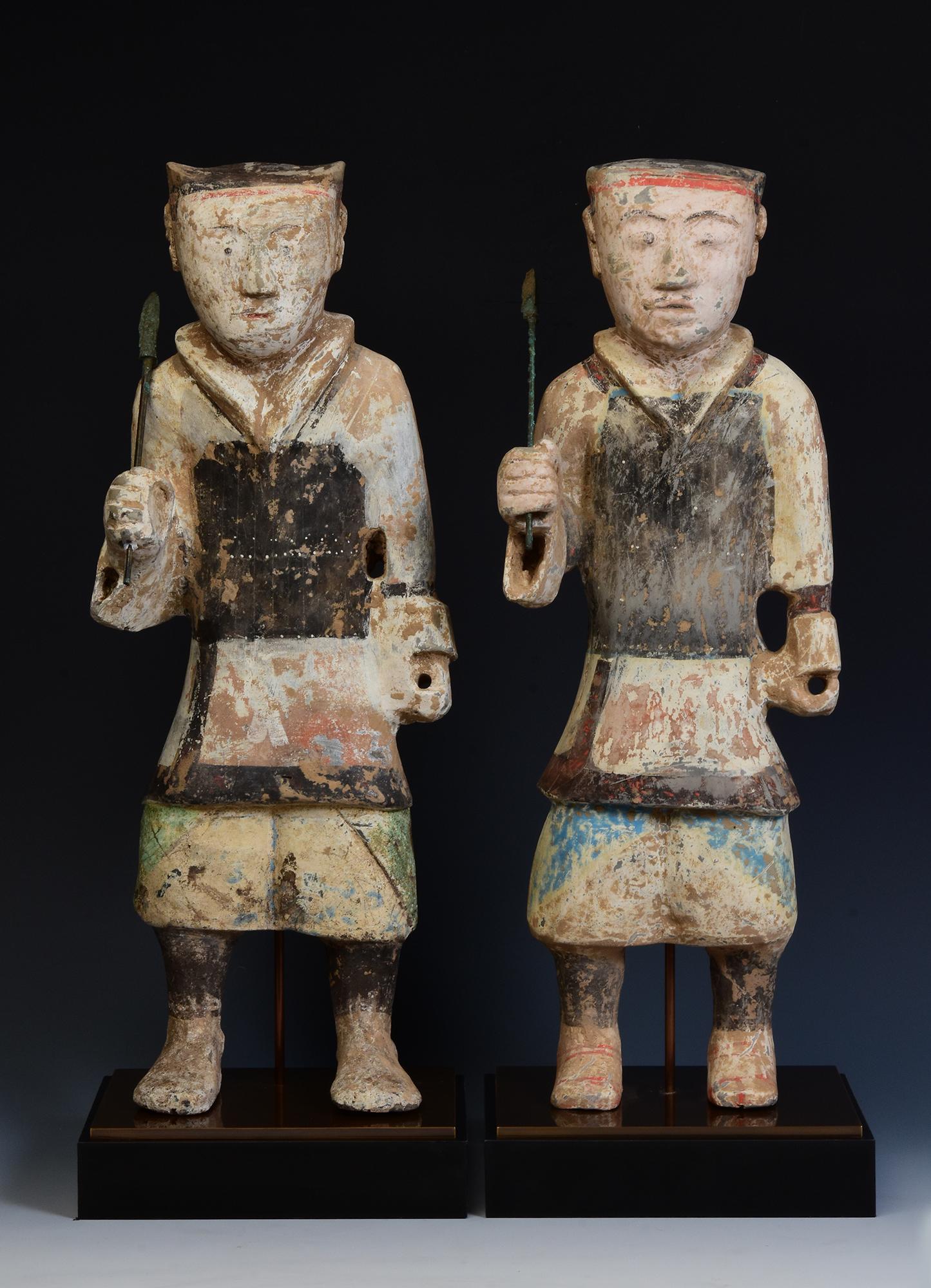 A pair of antique Chinese painted pottery standing warriors holding bronze spear with original pigments remaining.

Age: China, Han Dynasty, 206 B.C. - A.D. 220
Size of figure only: Height 46.5 C.M. / Width 17 - 17.5 C.M. / Depth 10.5 - 12.5