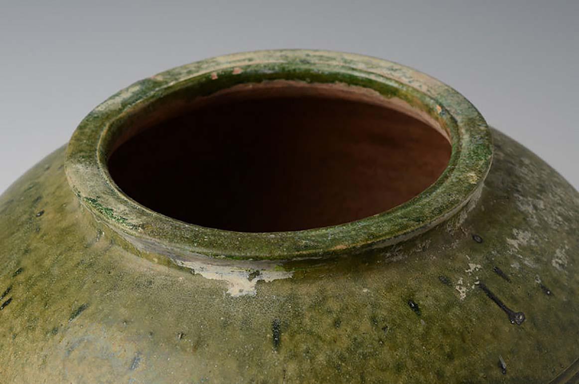 Chinese green glazed pottery jar in globular form with plain decoration. 
Lead glaze with copper is the main colorant used in Han period to produce green glaze. Greenware became popular during the Eastern Han period.

Age: China, Han Dynasty, 206
