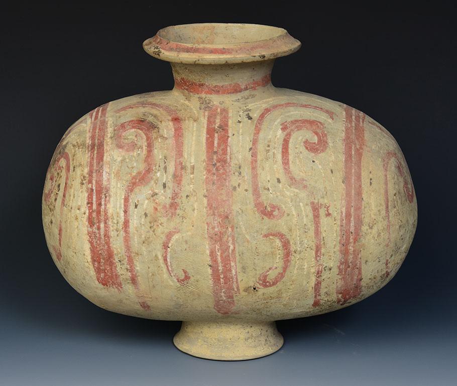 Chinese painted pottery cocoon jar painted with swirling design with red and white pigments. 
The cocoon jar is sometimes called a 