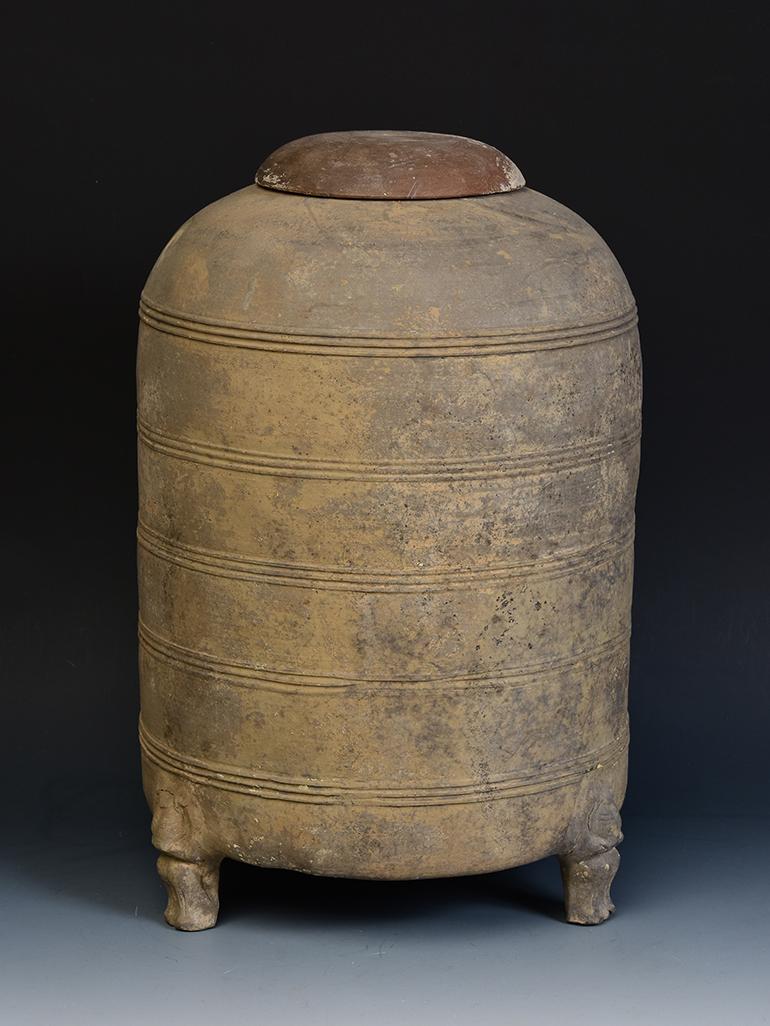 Chinese pottery granary jar with lid, with cylindrical shape, decorated with bands of incised lines, and supported by three legs. 

Age: China, Han Dynasty, 206 B.C. - A.D. 220
Size: Height 36.5 C.M. / Width 23 C.M.
Condition: Well-preserved old