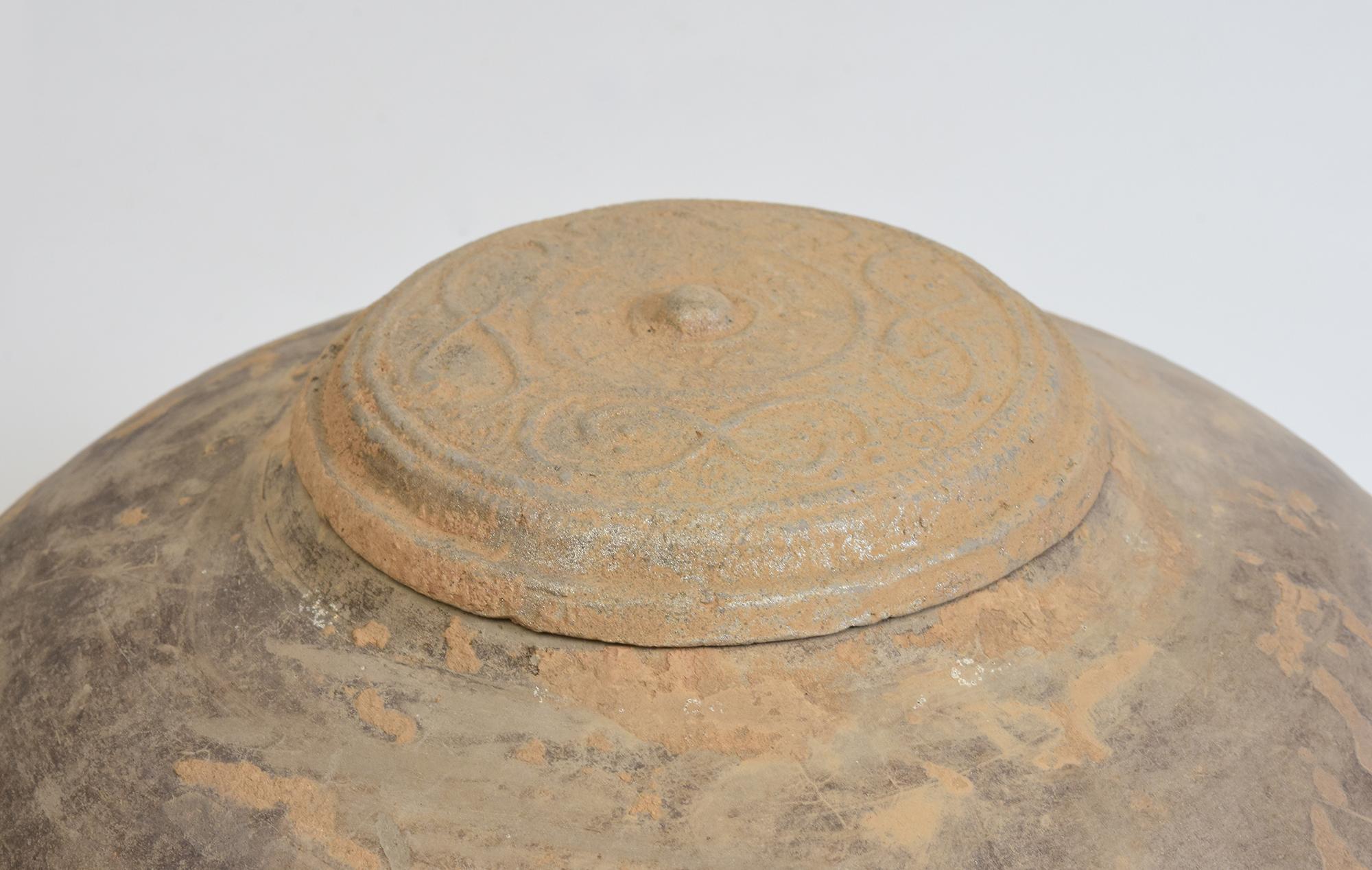 Antique Chinese pottery granary covered jar, with round shape, decorated with bands of incised lines on the body and supported by three legs.

Age: China, Han Dynasty, 206 B.C. - A.D. 220
Size: Height 31.4 C.M. / Width 32 C.M.
Condition: