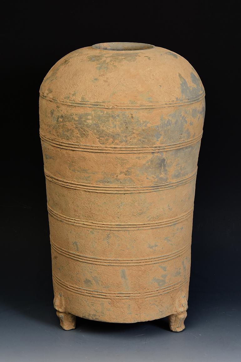 Chinese pottery granary jar, with cylindrical shape, decorated with bands of incised lines, and supported by three legs. 

Age: China, Han Dynasty, 206 B.C. - A.D. 220
Size: Height 40.5 C.M. / Width 23 C.M.
Condition: Well-preserved old burial